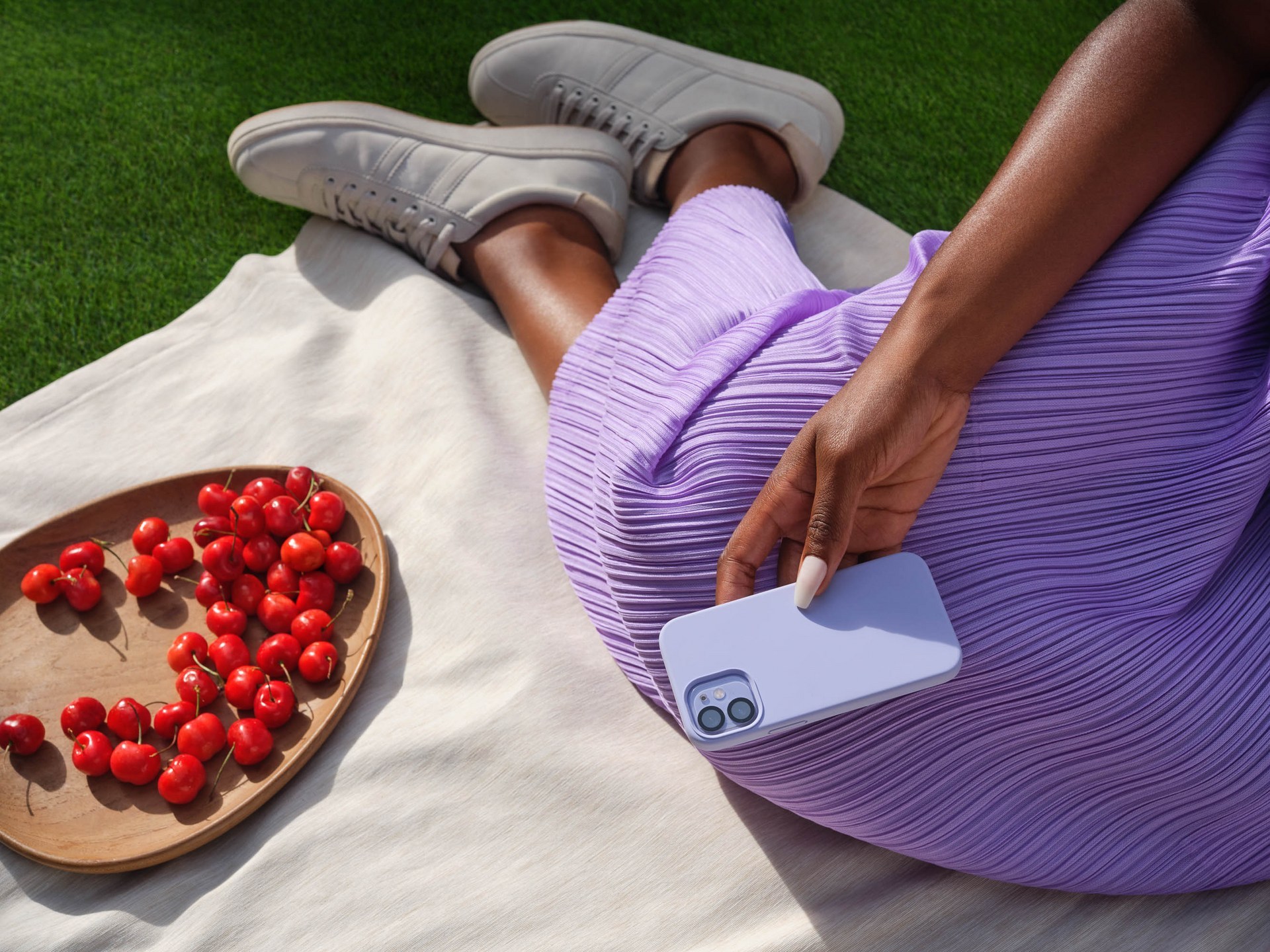 close-up shot of a woman sitting beside red cherries