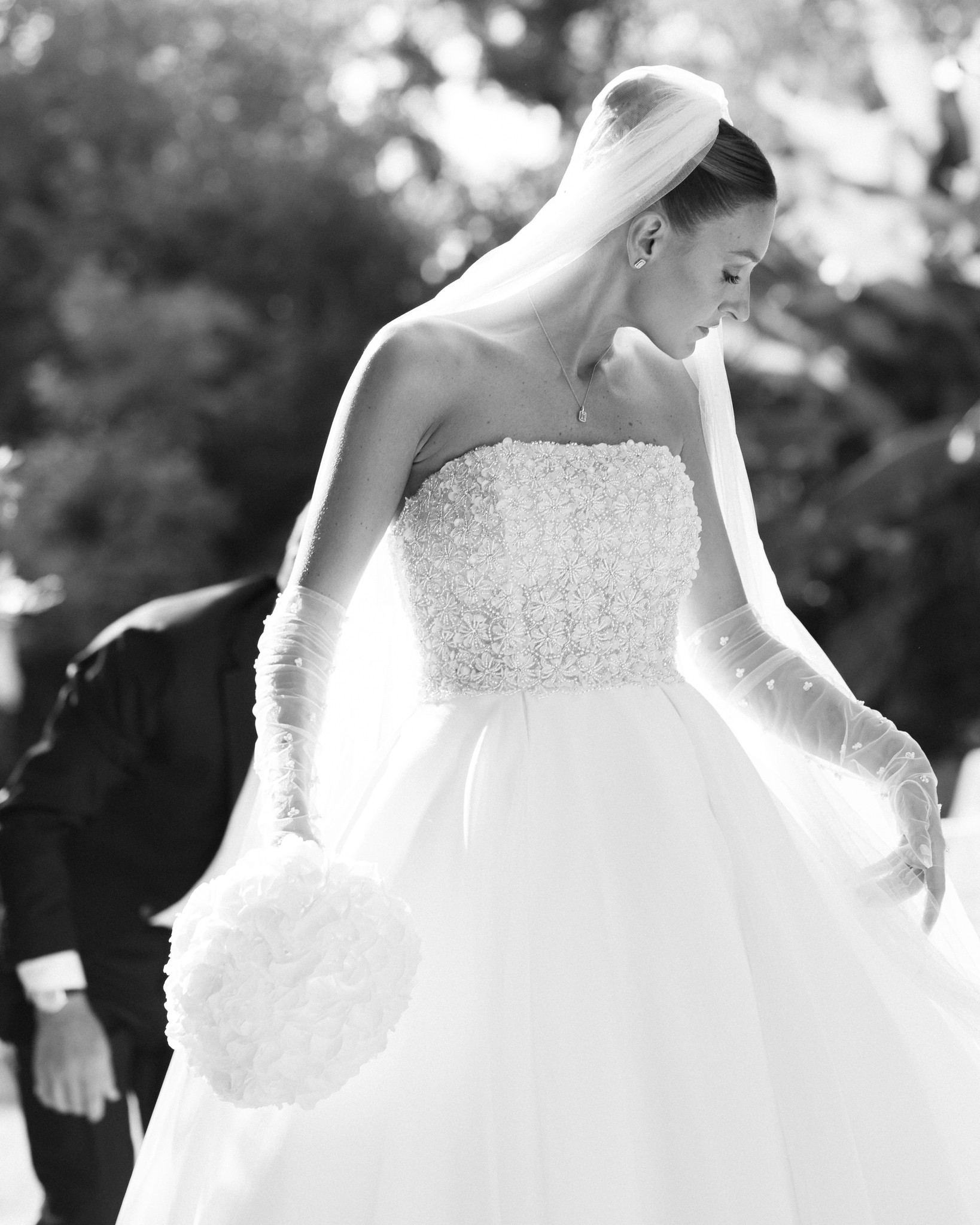 Sposa in abito bianco ricamato con velo, ritratto di profilo a Villa Ferrari durante il reportage di matrimonio