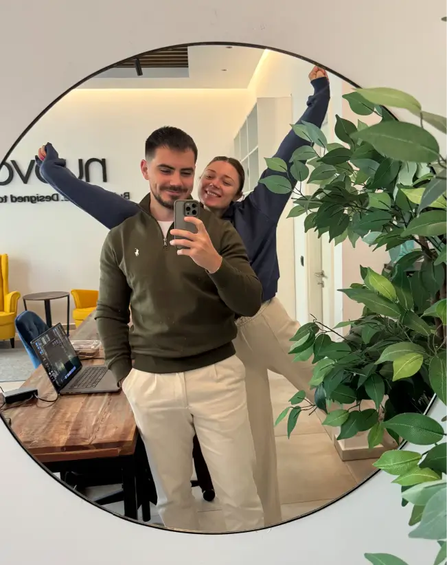 2 young man and woman taking an image in the mirror in an office
