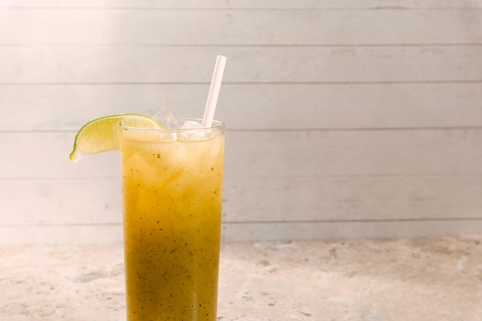 A tall iced drink with a lime wedge
