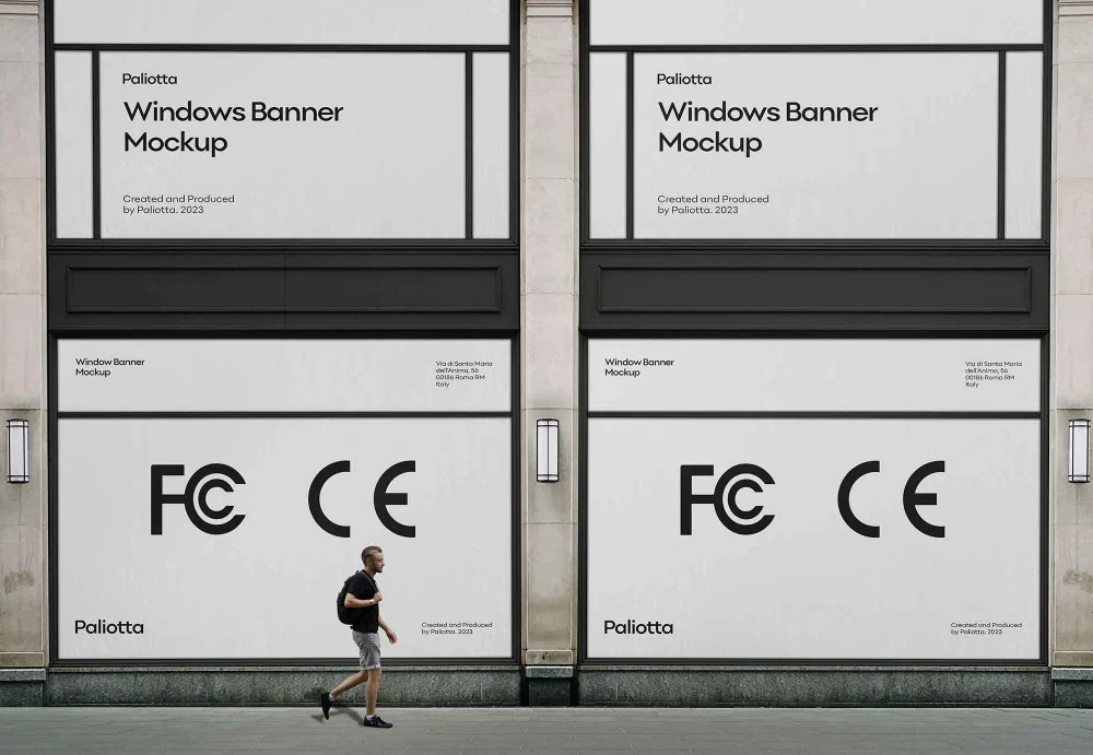 A pair of large black window banners with minimalist text and symbols displayed on a modern building facade. A pedestrian walks past on the sidewalk, adding scale and context to the urban setting.