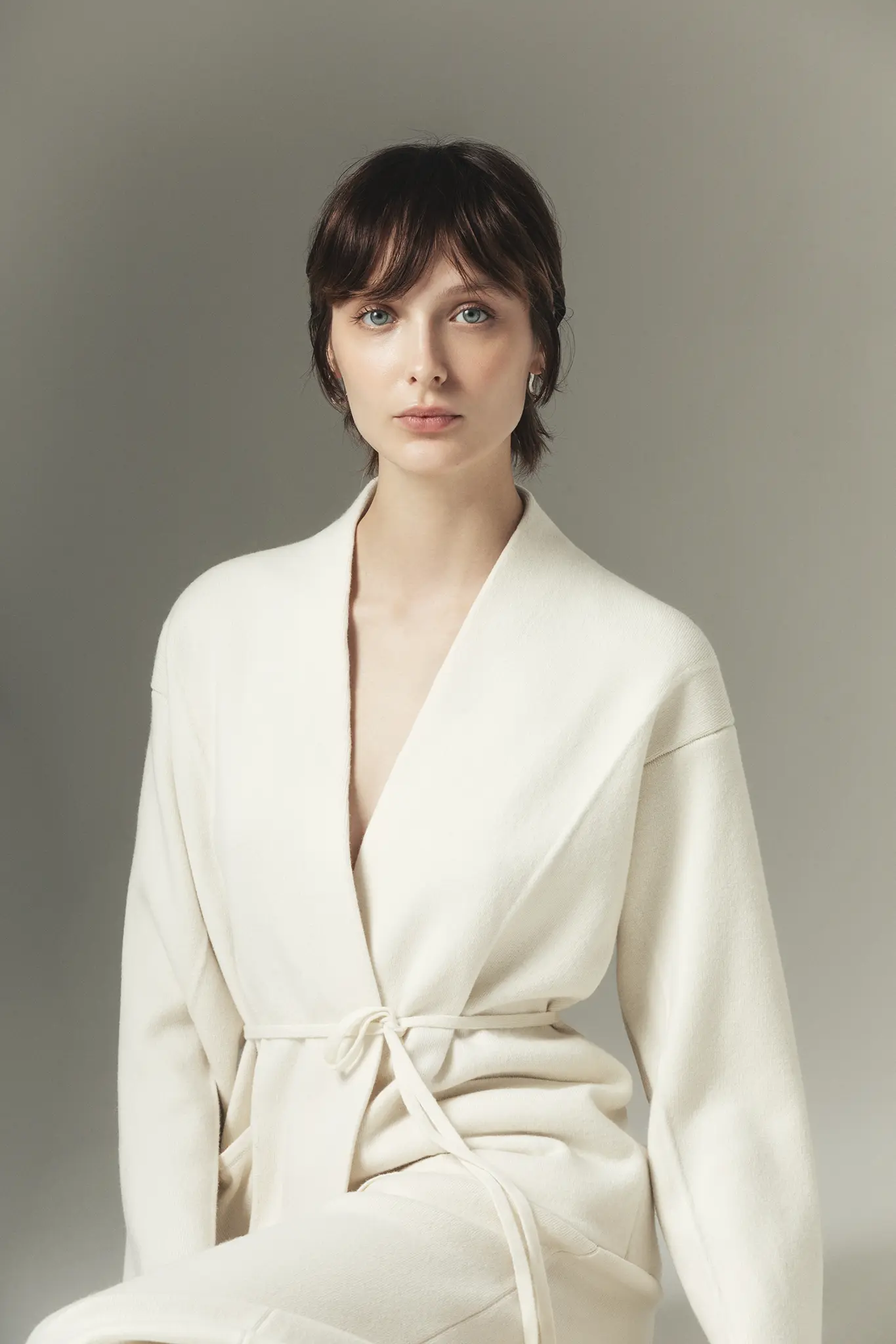 Portrait of a woman in ivory cashmere wrap jacket – Aida Barni Made in Italy craftsmanship.