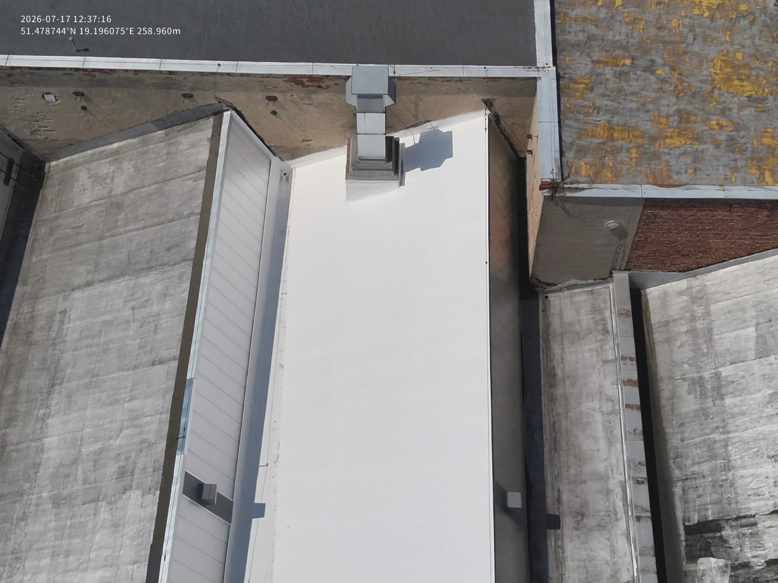 Widok z drona na jasną centralną połać dachu pokrytą ECOBAUTER SYSTEM ROOF w zakładzie TZMO w Zelowie.