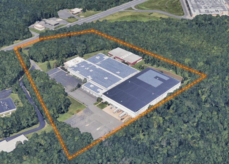 Tall modern skyscraper with vertical lines, viewed against a clear blue sky.