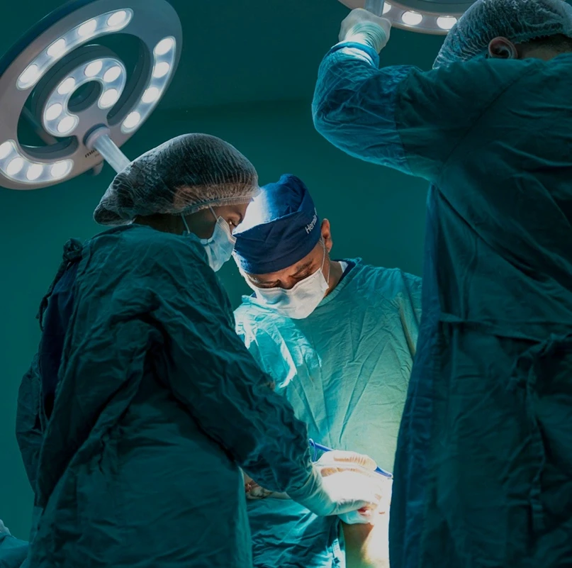 Surgical team performing an operation under clinical lighting in a hospital operating room