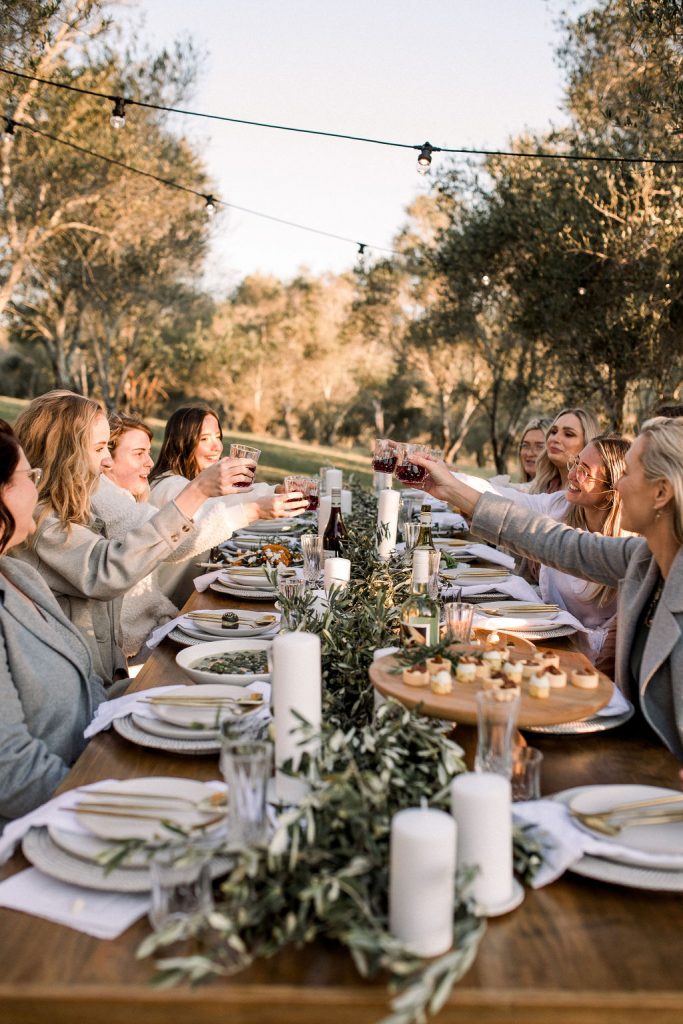 Family cheering drinks over an outdoor table set up at the Granary & Grove