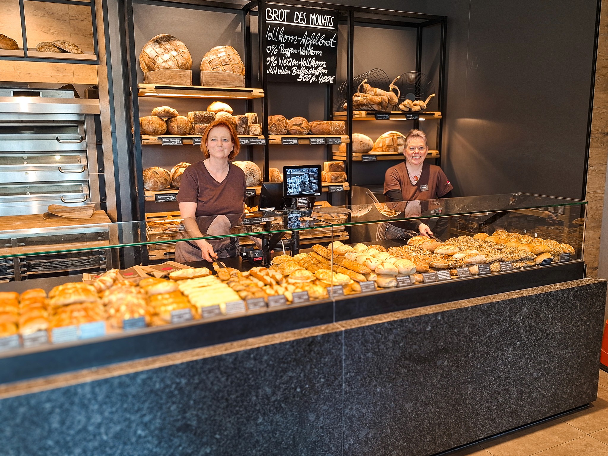 Mitarbeiterin lächelt hinter der Brot-Theke bei Bäckerei-Stöckle