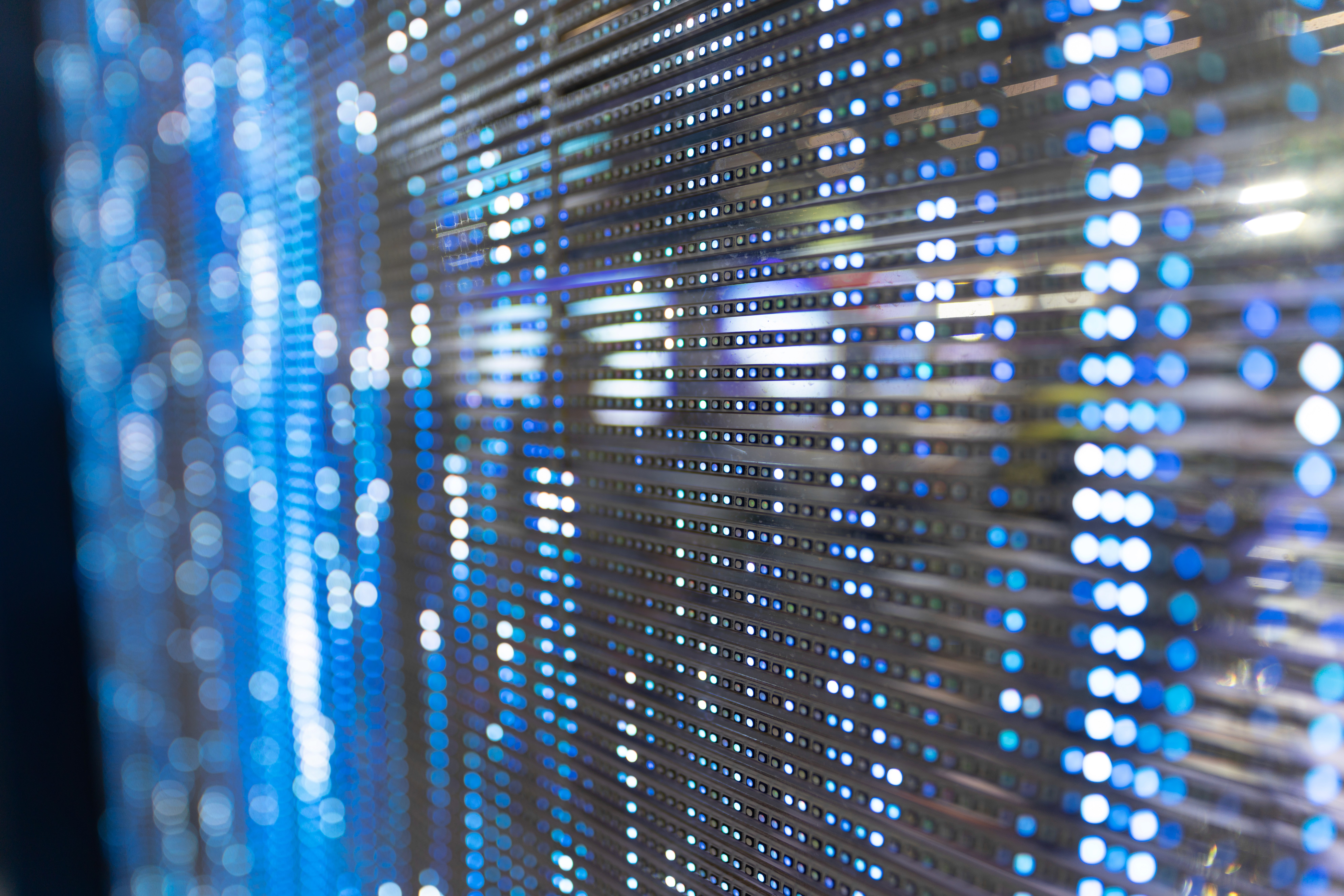 Modern office building with large windows reflecting a vivid orange sunset sky, silhouetted figure visible through the glass.