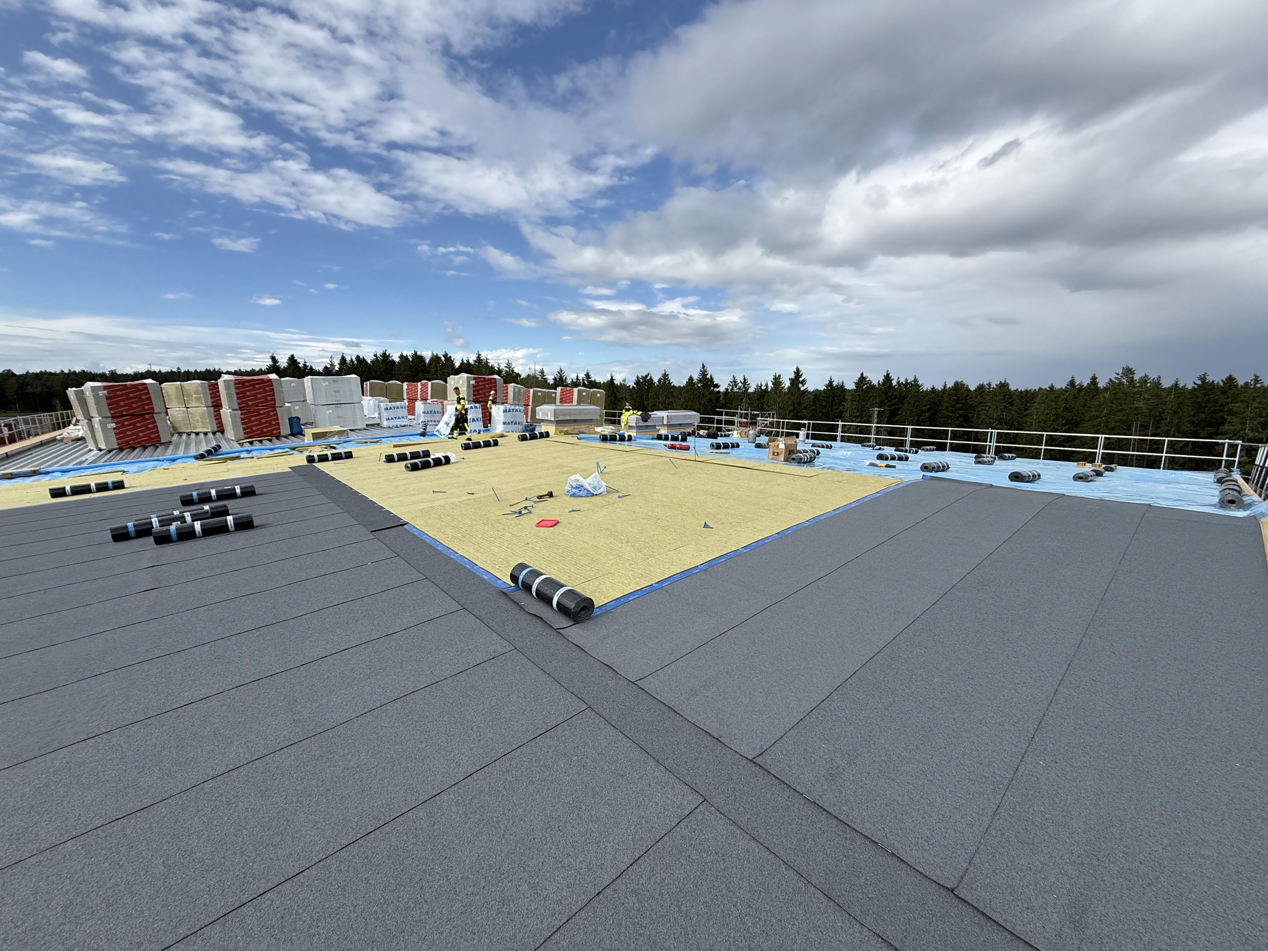 Roofers working with insulation boards on the roof