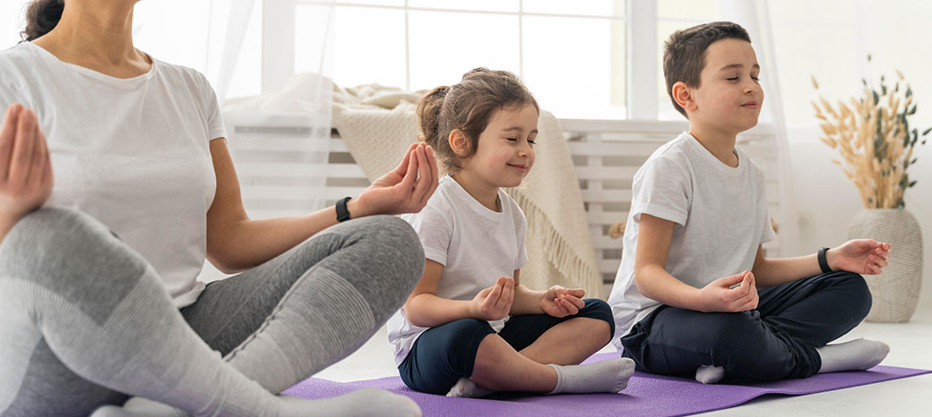Students practicing mindfulness and flexibility during guided yoga session in after school wellness program
