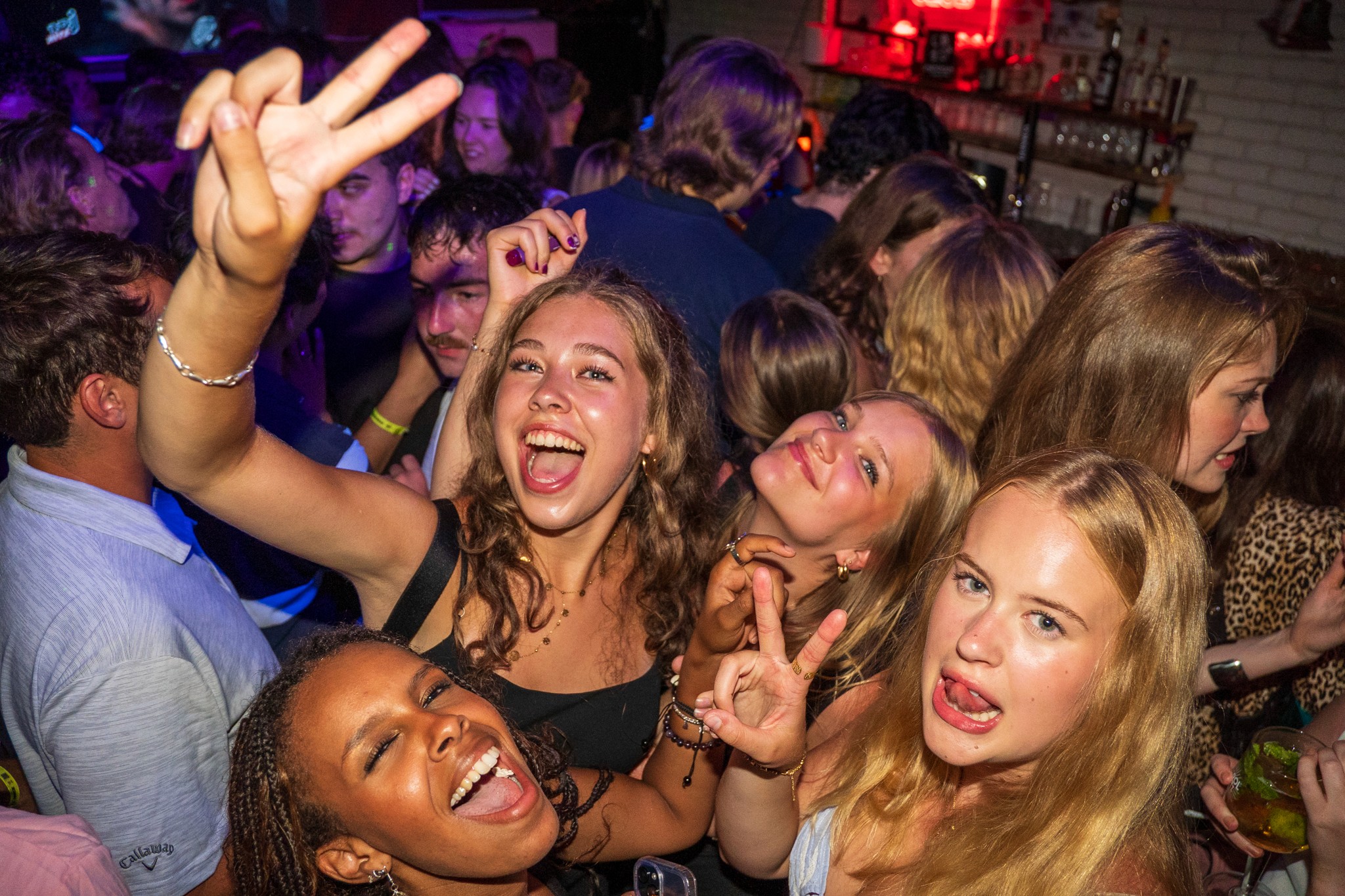 Group of young partygoers dancing and celebrating inside a crowded bar during a bar crawl in Nice capturing wild energy social connection and the high intensity nightlife atmosphere of the French Riviera