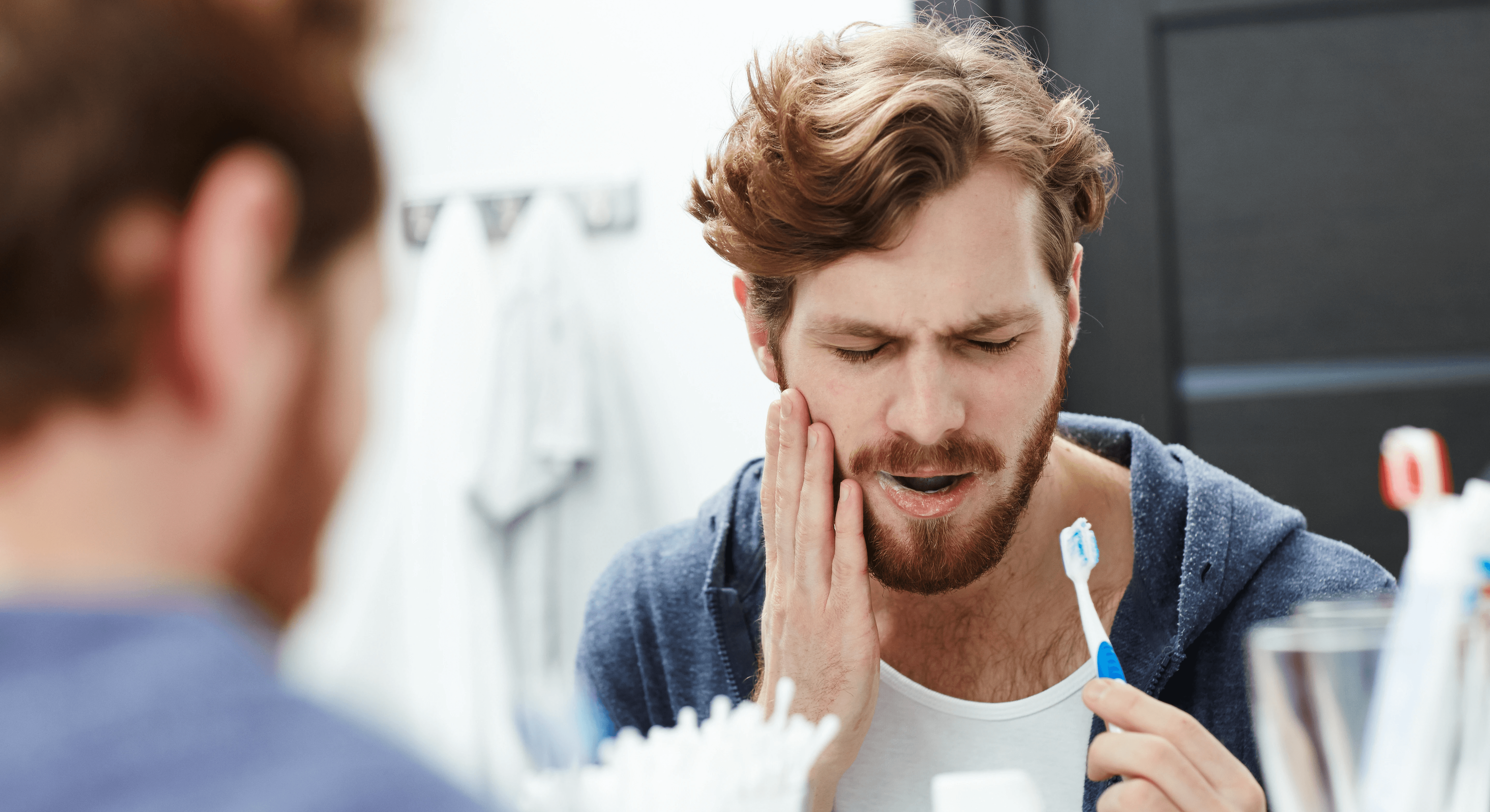 A man with a toothache in his wisdom teeth, the painful area highlighted in red, by Invisalign Center