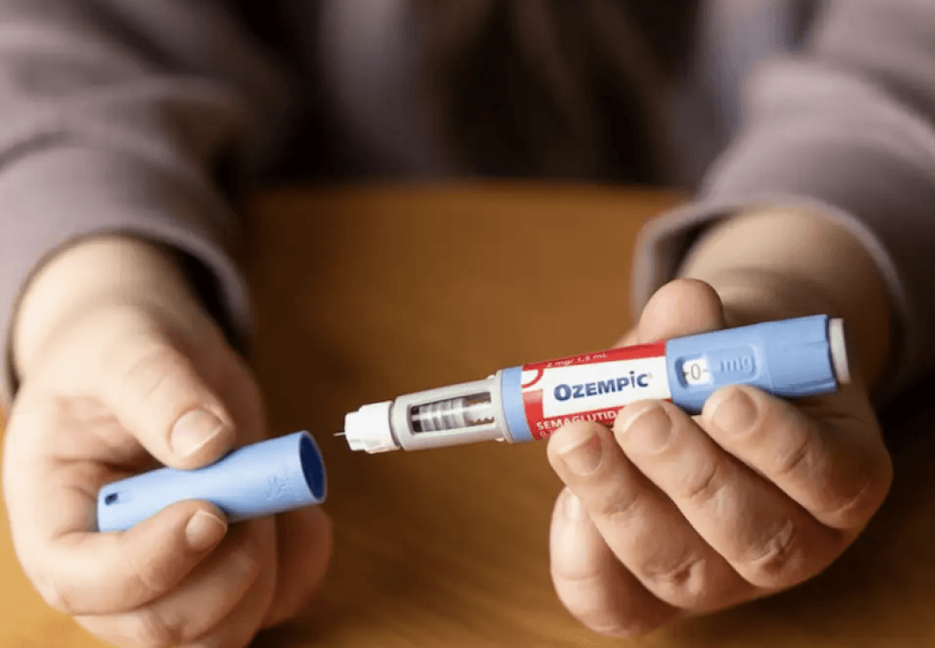 person holding injectable medication pen related to weight loss drugs