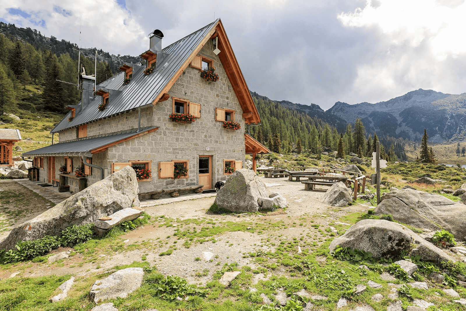 Traditional Trentino dinner at a remote Alpine hut, showcasing the authentic 'Rod Society' experience of local culture and mountain flavors