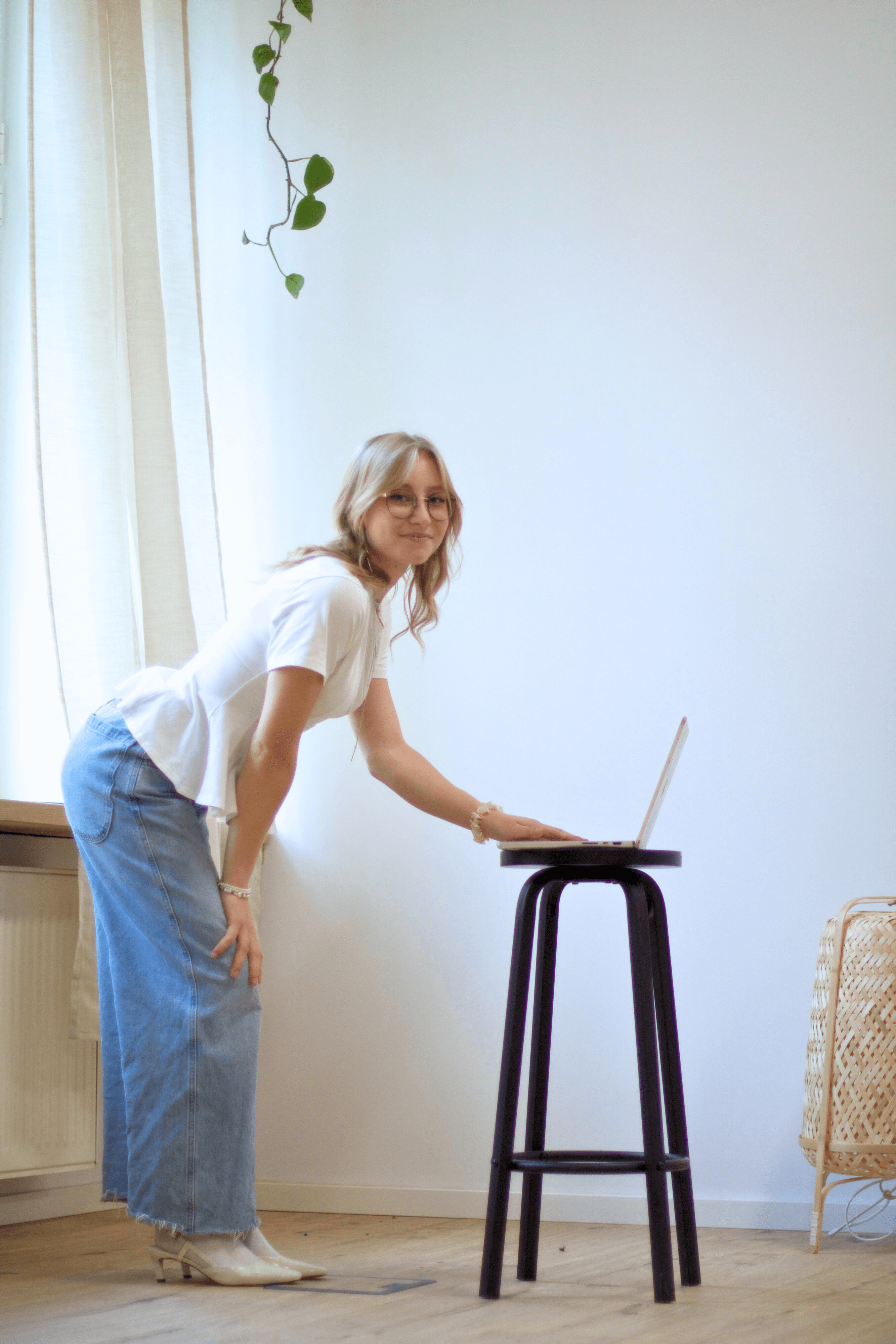 Yasmin schaut in die Kamera während sie auf ihrem Laptop tippt