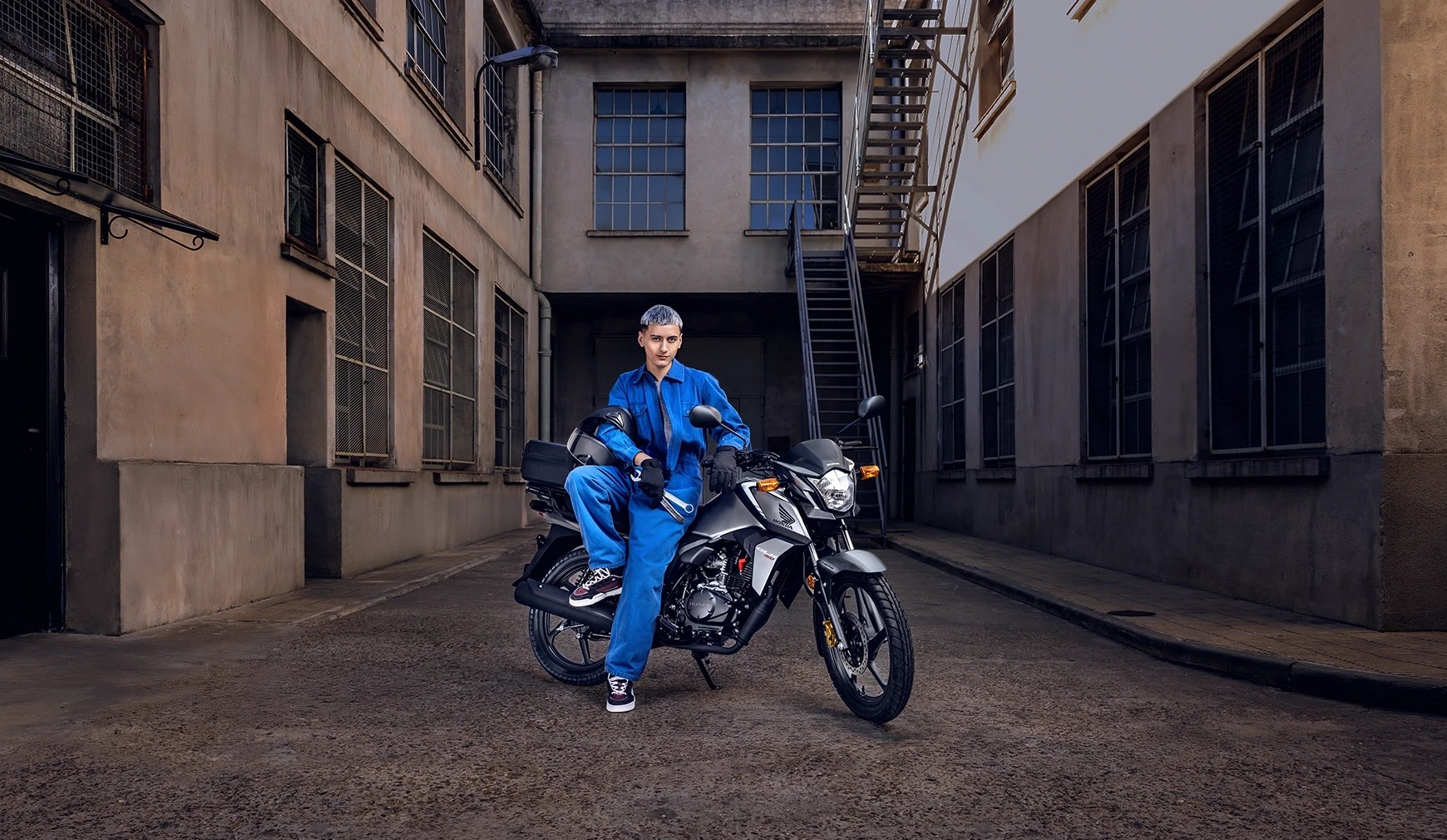 Mecánico sobre Honda GLH 150 negra en un callejón