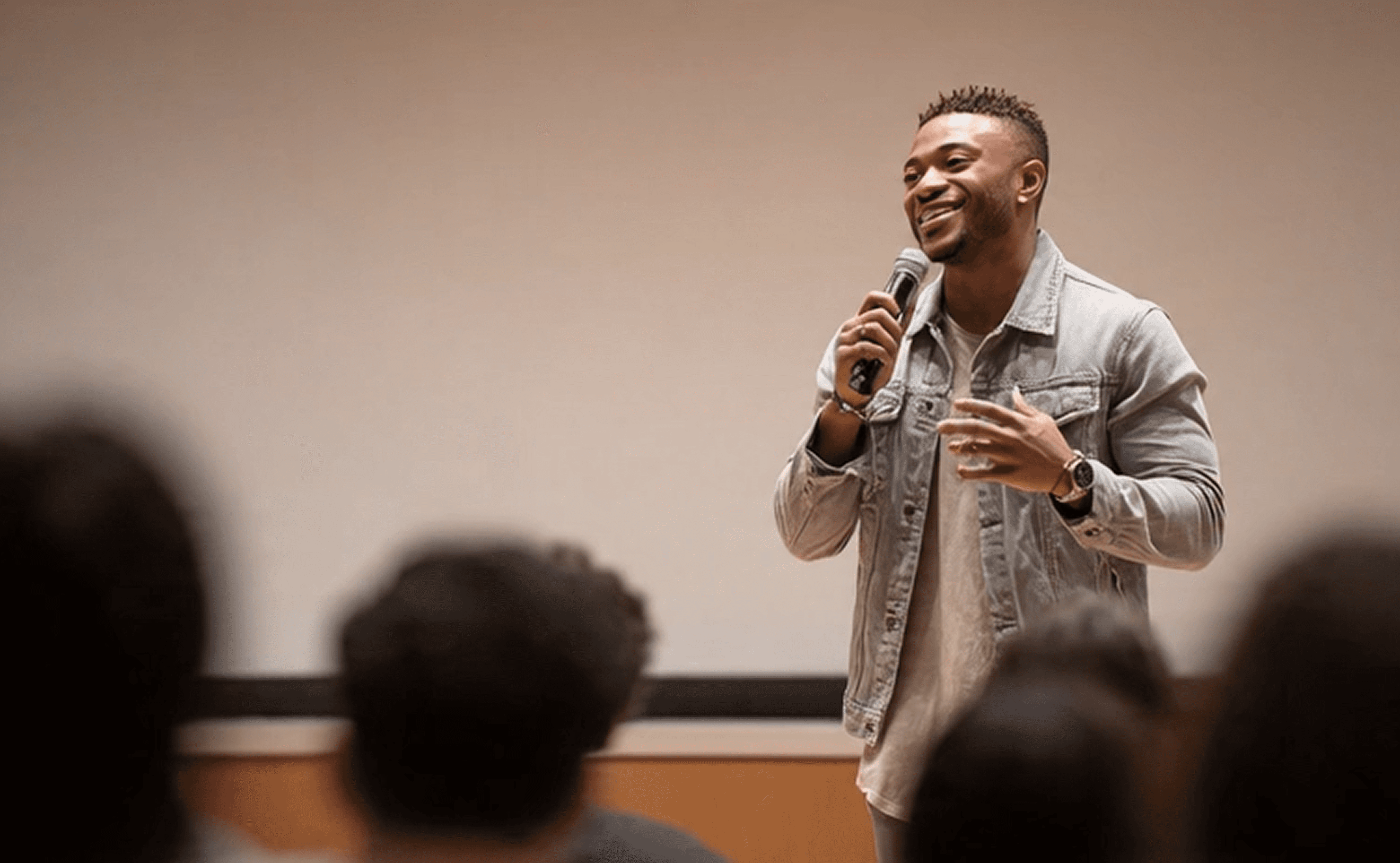 Young man in asks a question into a conference mic.