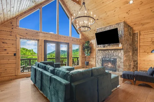 Cabin living room with a green sofa and stone fireplace