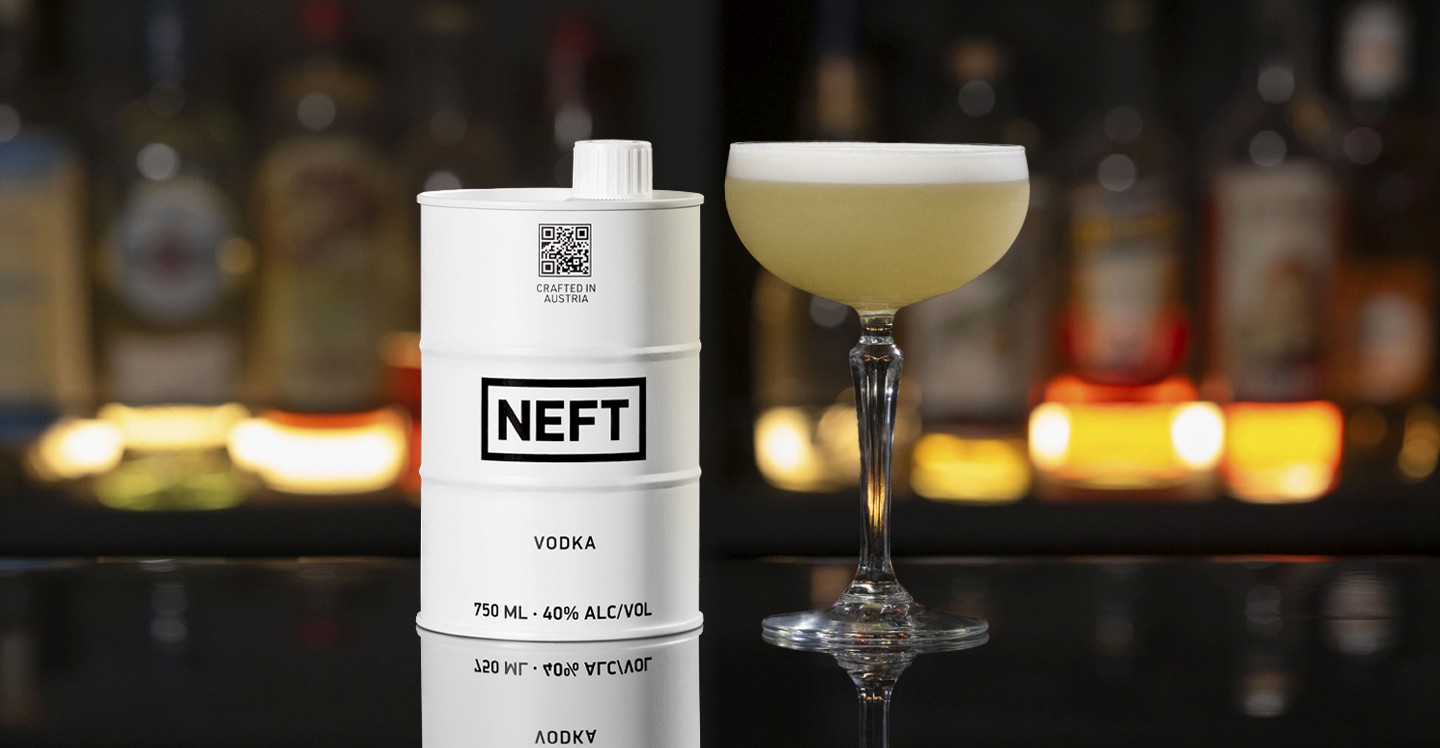 A NEFT Barrel and a glass of NEFT Sour on a bar counter.