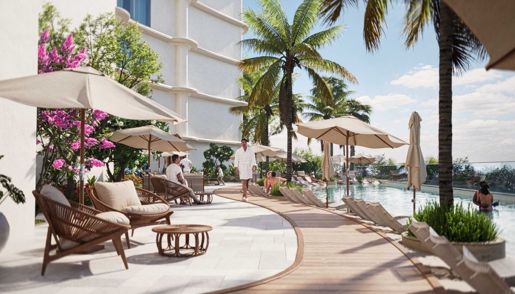 A tranquil pool area featuring lounge chairs and umbrellas, adjacent to a beach with azure Lapis hues.