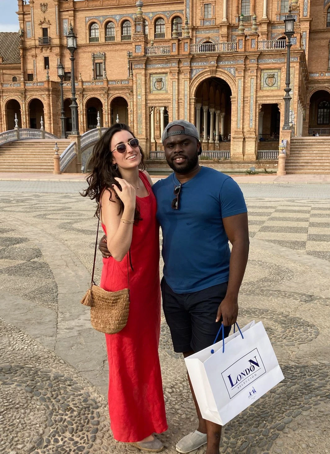 A close-up of two people holding hands, one wearing a denim jacket. The background is softly blurred, suggesting a tender, intimate moment in warm light.