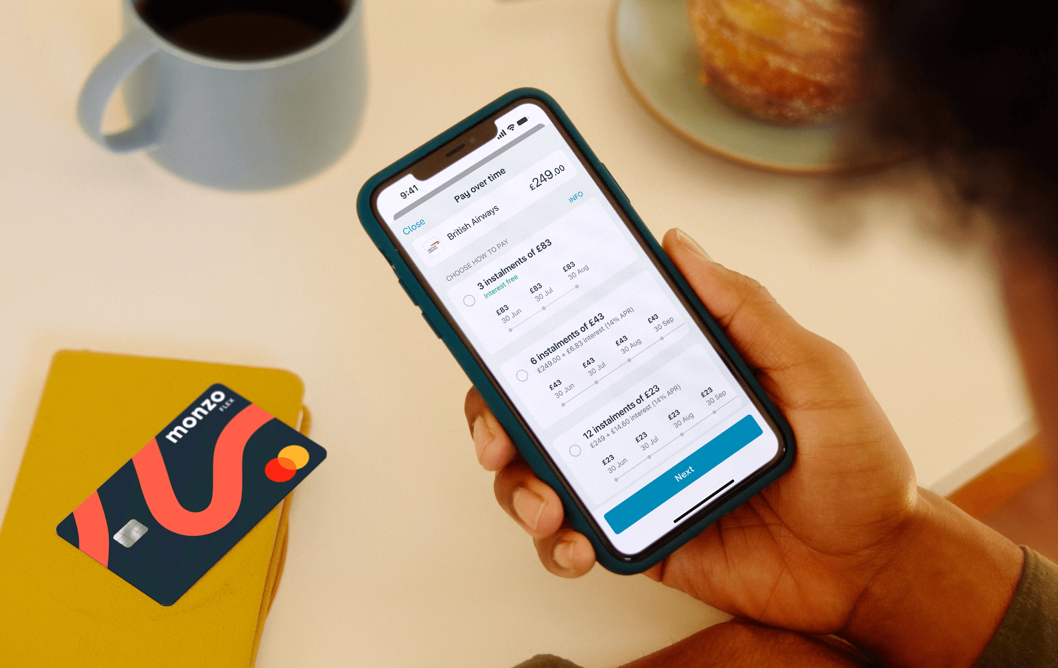 An image of a person in a cafe managing their payments in the Monzo online banking app