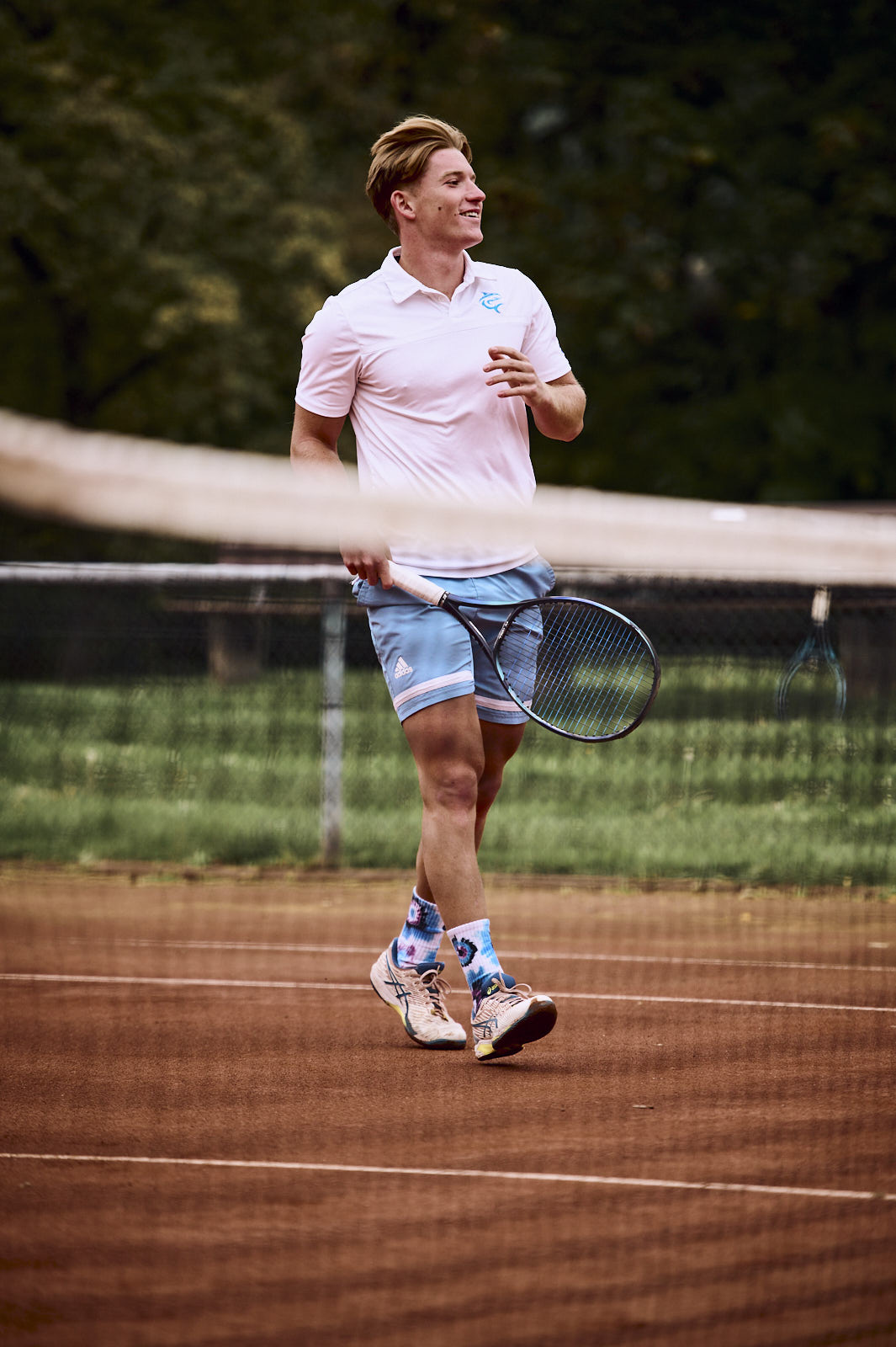 Felix Einig lächelt auf einem Tennisplatz