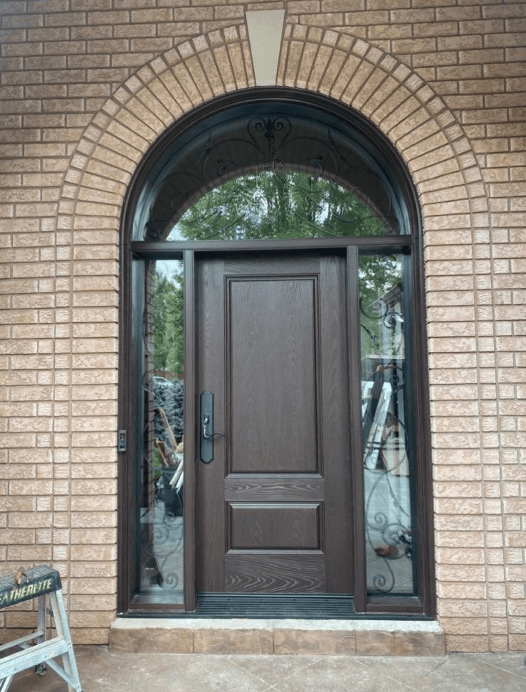 Arched fiberglass entry door with decorative glass sidelites set into an existing brick archway in Ontario