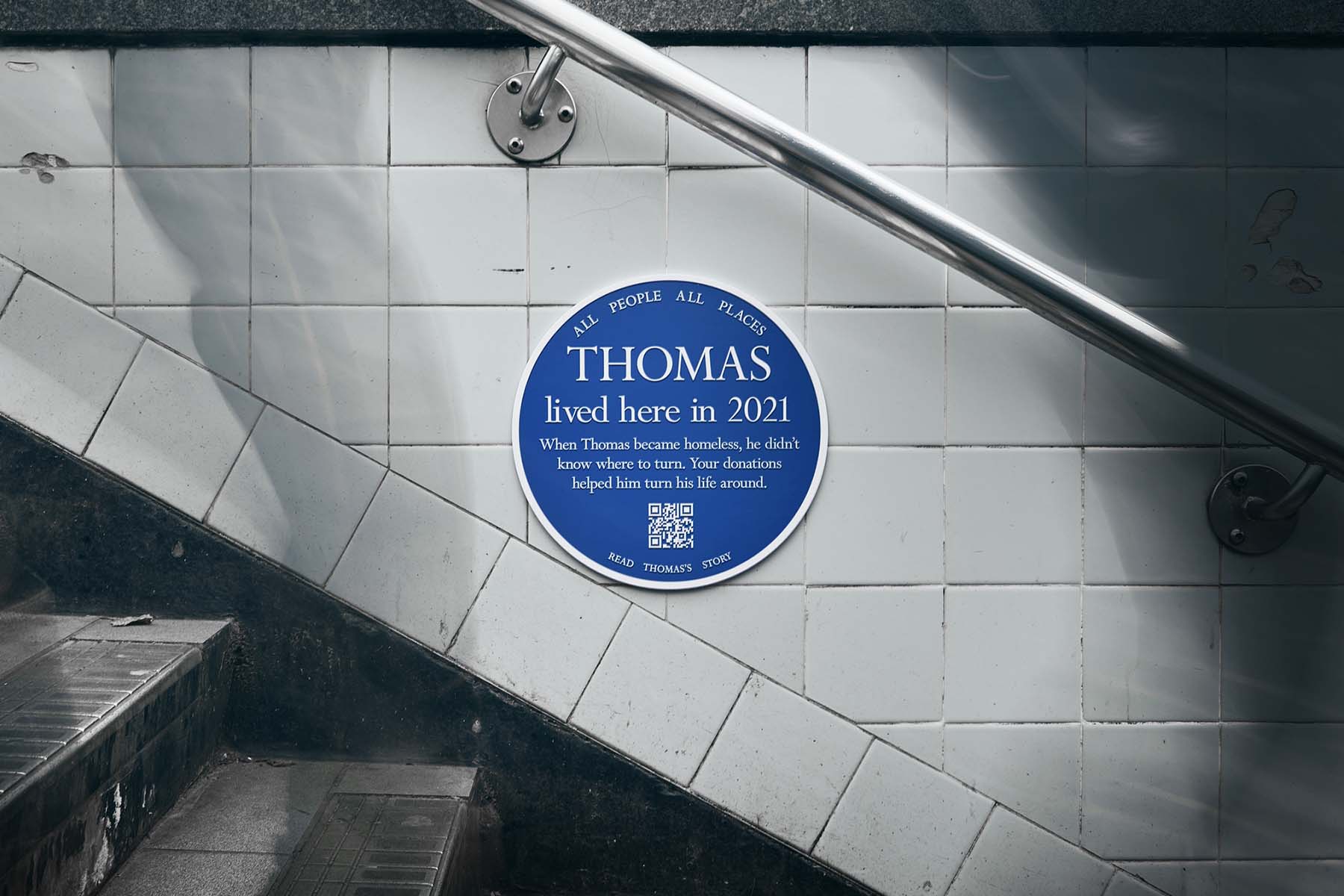 Blue plaque attached to a subway staircase that says Thomas lived here in 2021