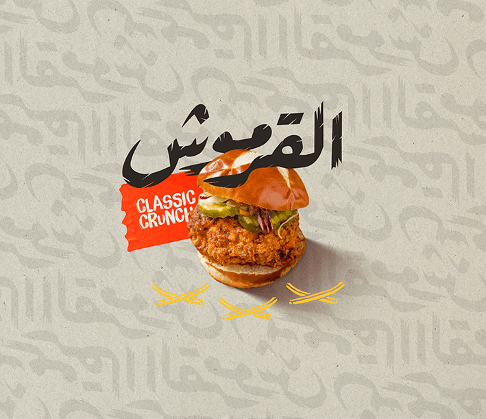 Chips & Chicks Classic Crunch chicken burger — crispy fried chicken sandwich with pickles and slaw on brioche bun, Arabic calligraphy 'القرموش' with red label and crossed fries icons — bilingual F&B menu design and food photography by Makers' Studio