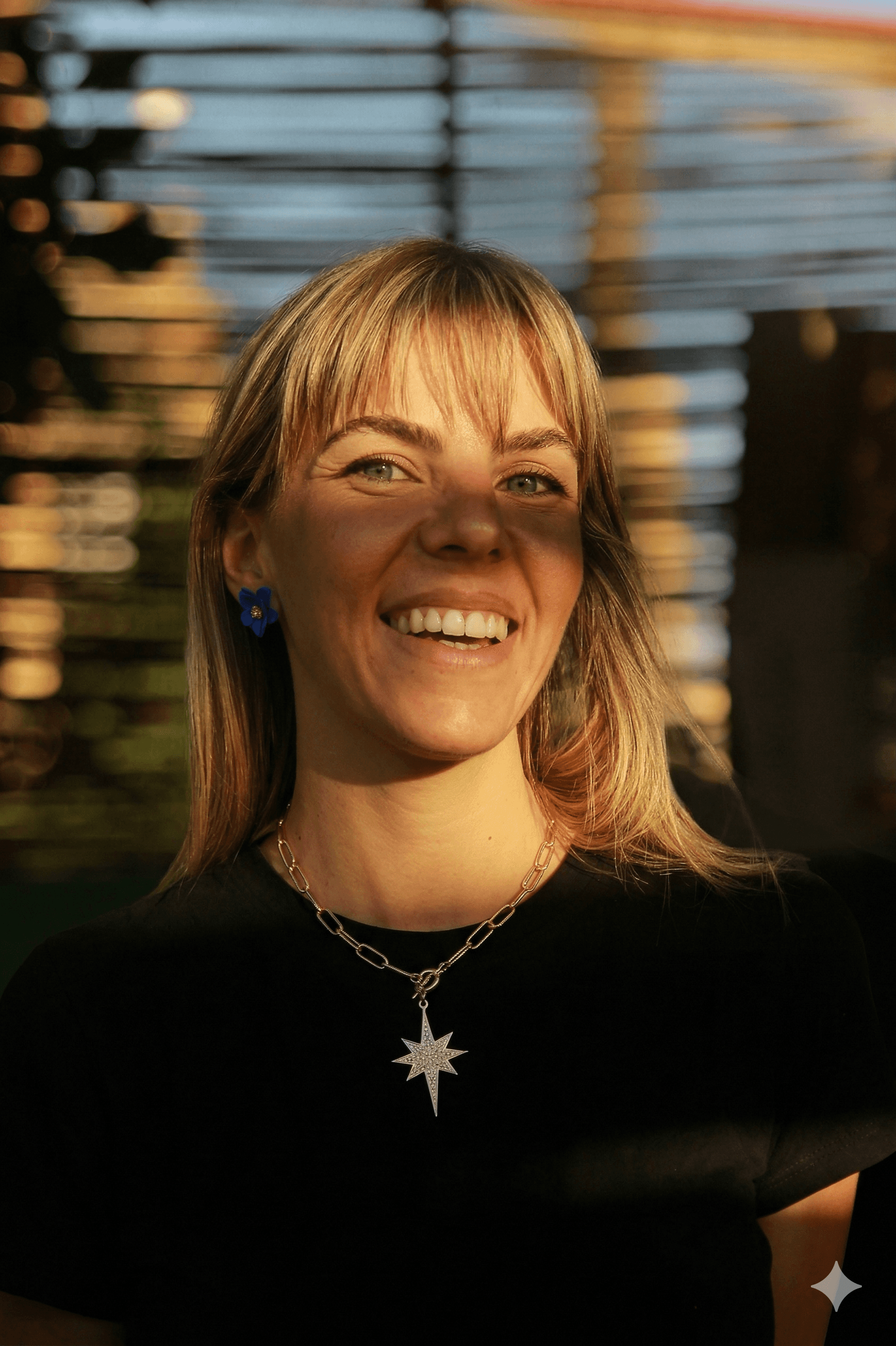 a young man wearing glasses standing in front of a mountain