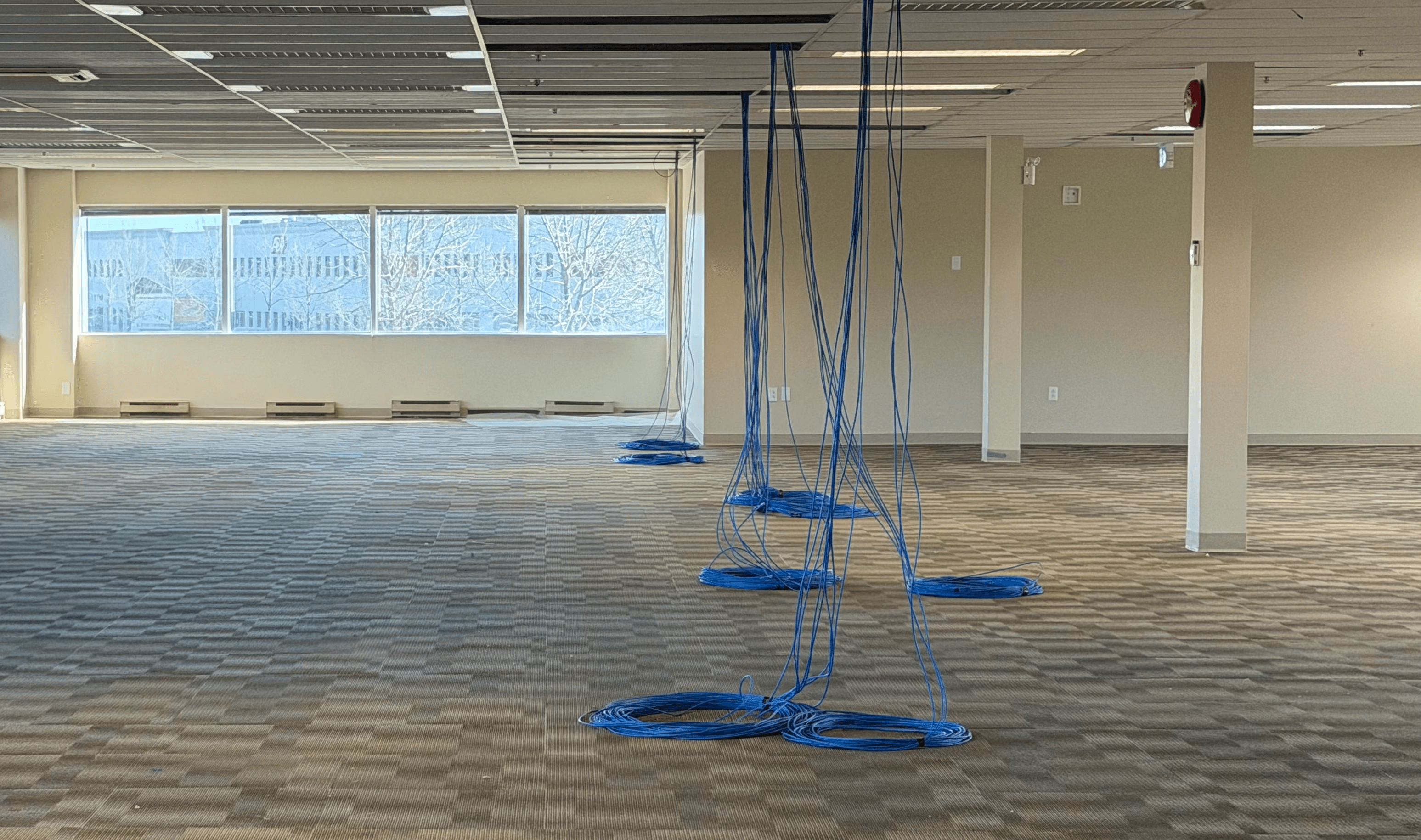 Technician performing network cabling installation and cable management in a server room