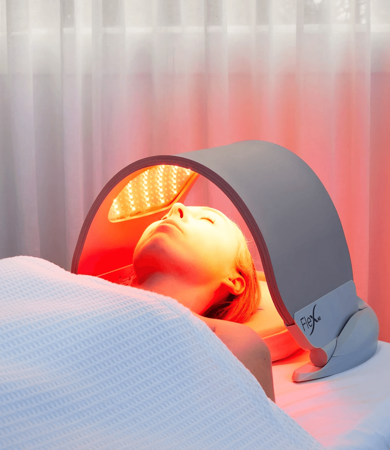 Woman receiving facial treatment with metal tools.