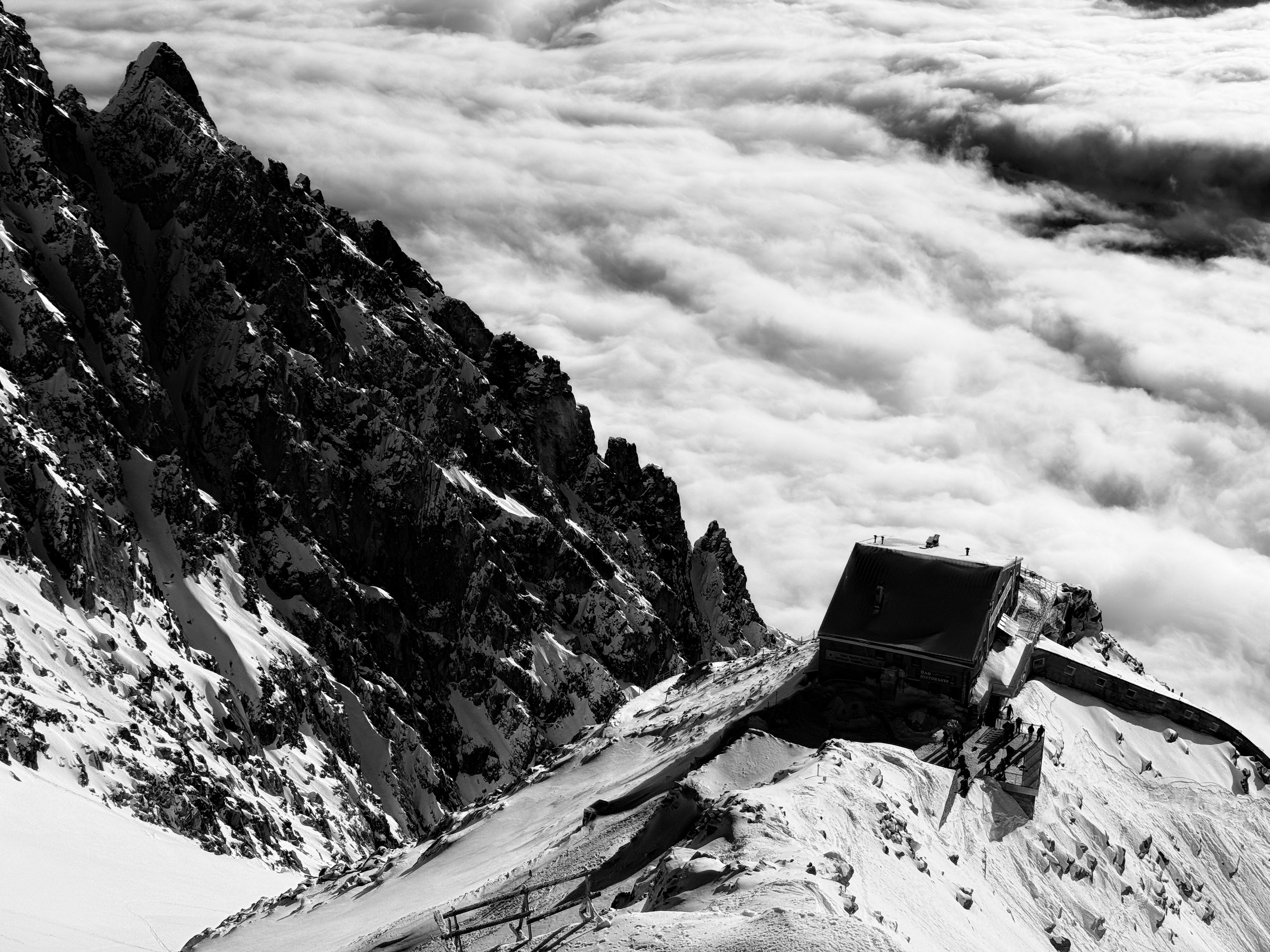 Stone mountain refuge below Punta Helbronner, Mont Blanc massif, above a sea of clouds