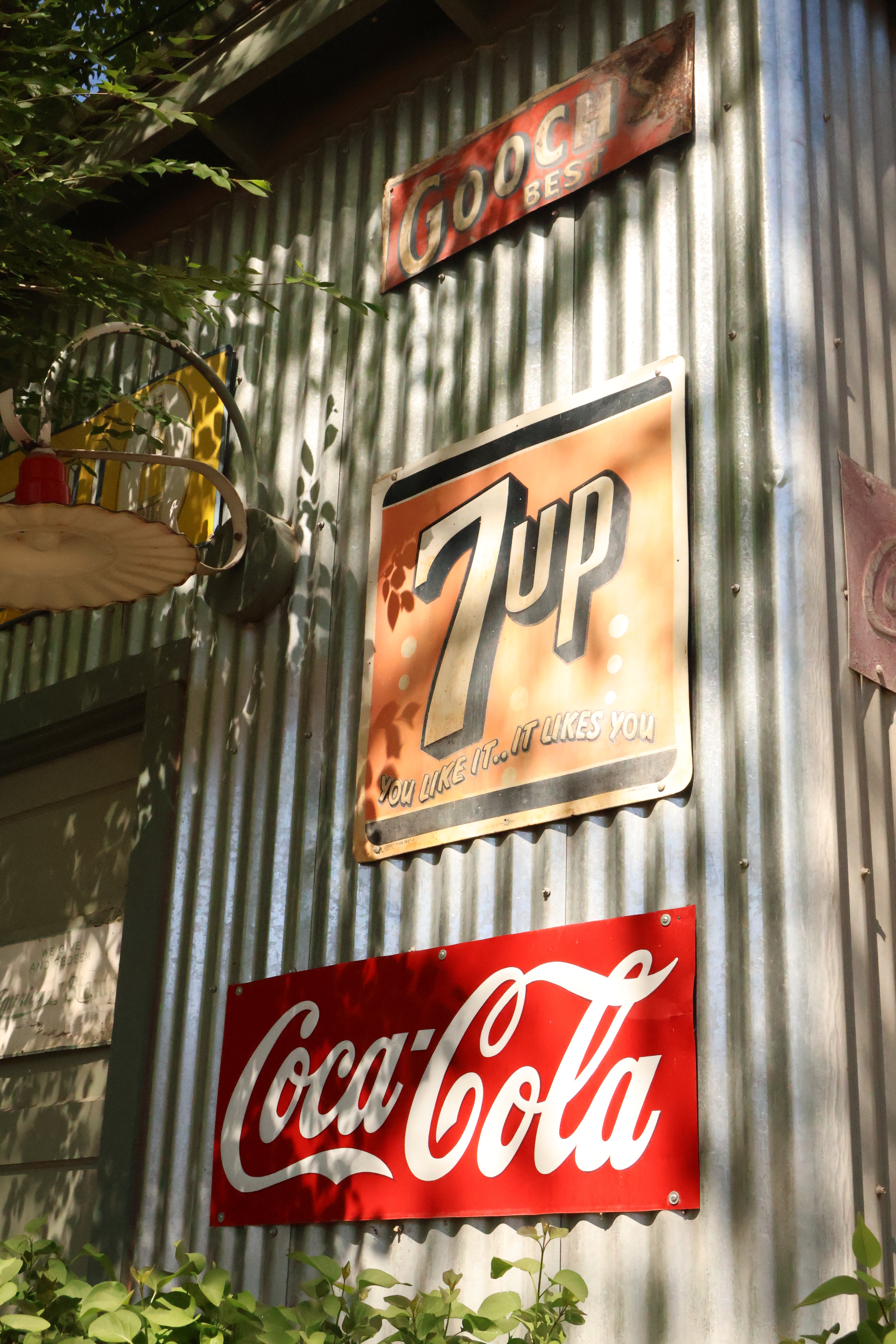 Vintage Coca-Cola, 7UP, and Goodyear signs displayed on a historic corrugated metal shed at Mi Amore Sedona in Sedona Arizona
