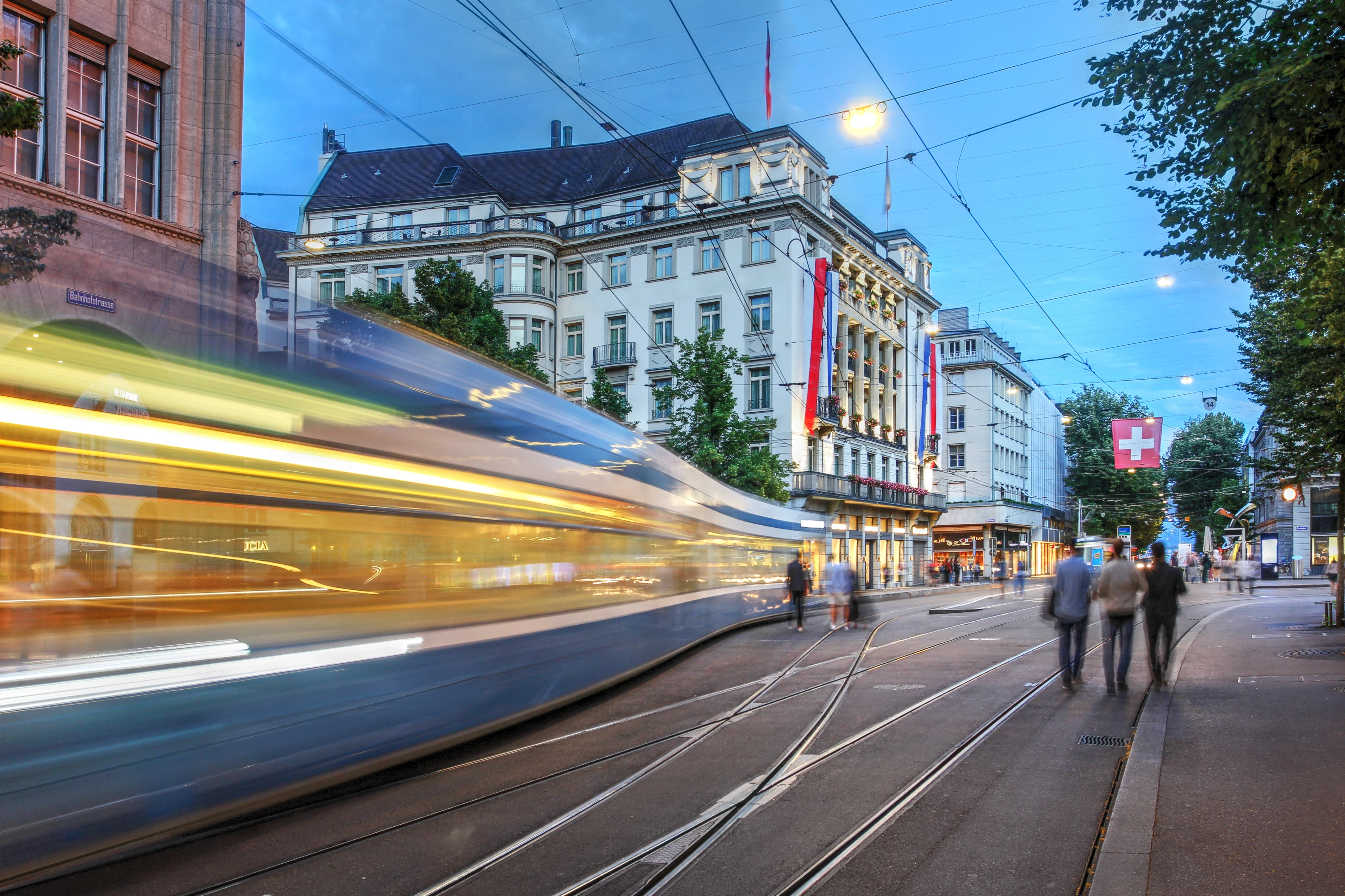 Downtown Zurich with glowing tram lights at dusk symbolizing the creative spirit of Mizuri, a Swiss marketing agency