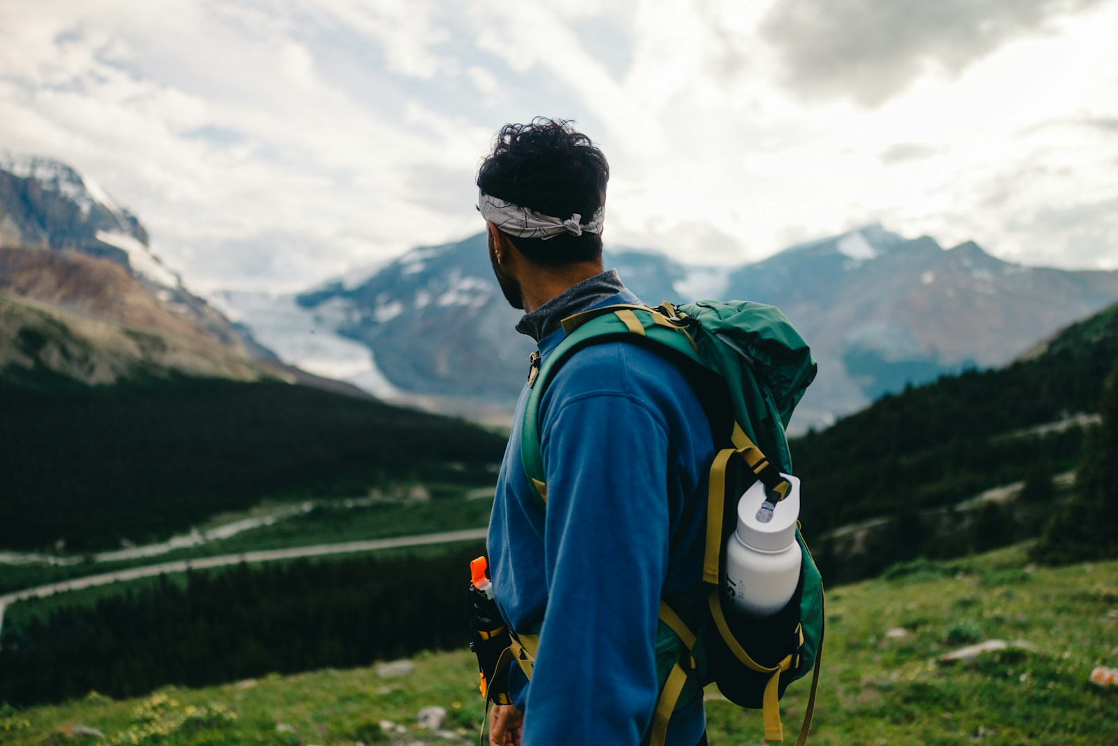 Hiker with a backpack looking out over a mountain valley