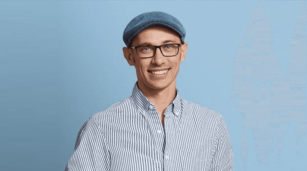 Man with glasses and blue cap smiling