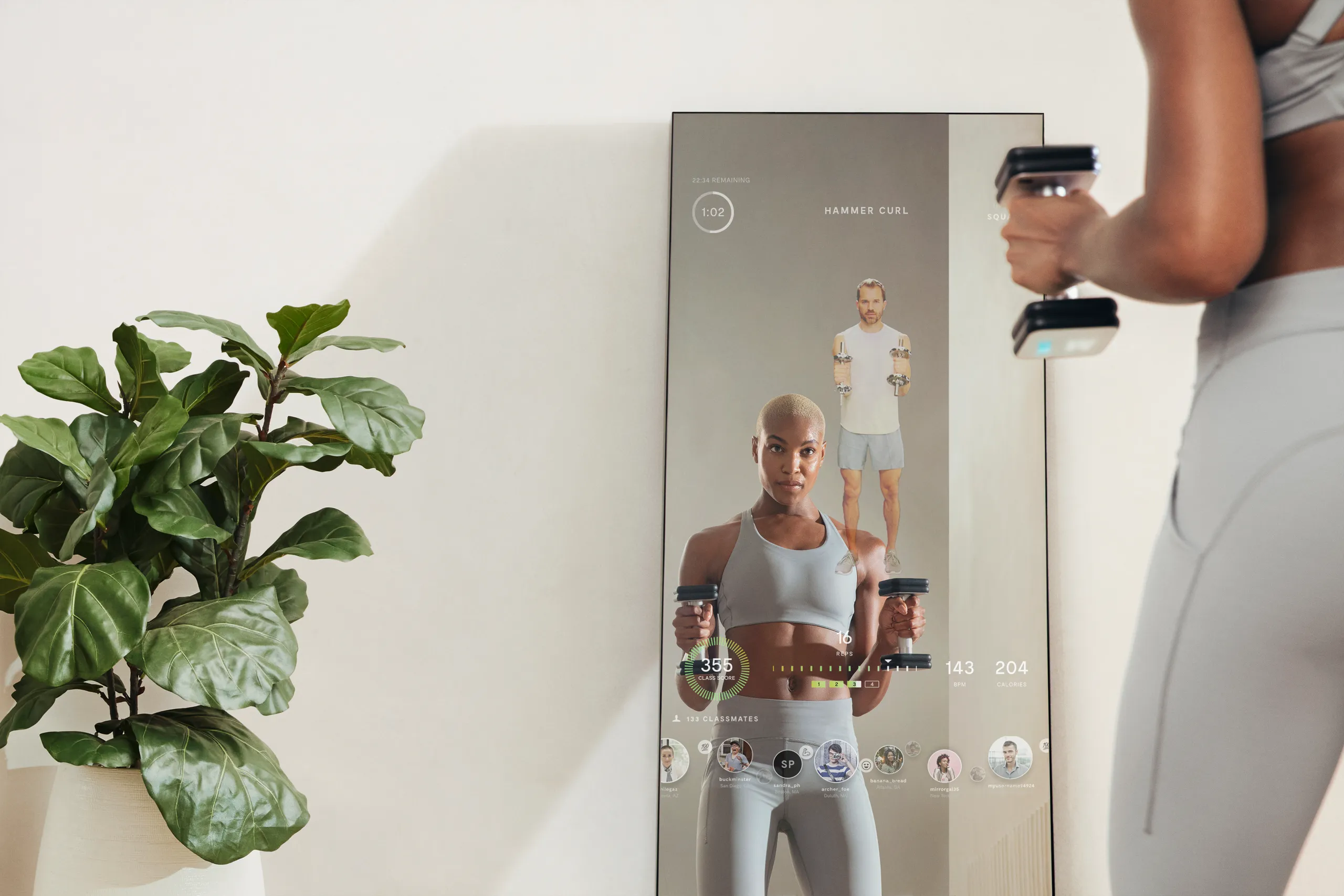 Person exercising with a Mirror smart dumbbell while following a connected workout on the fitness mirror