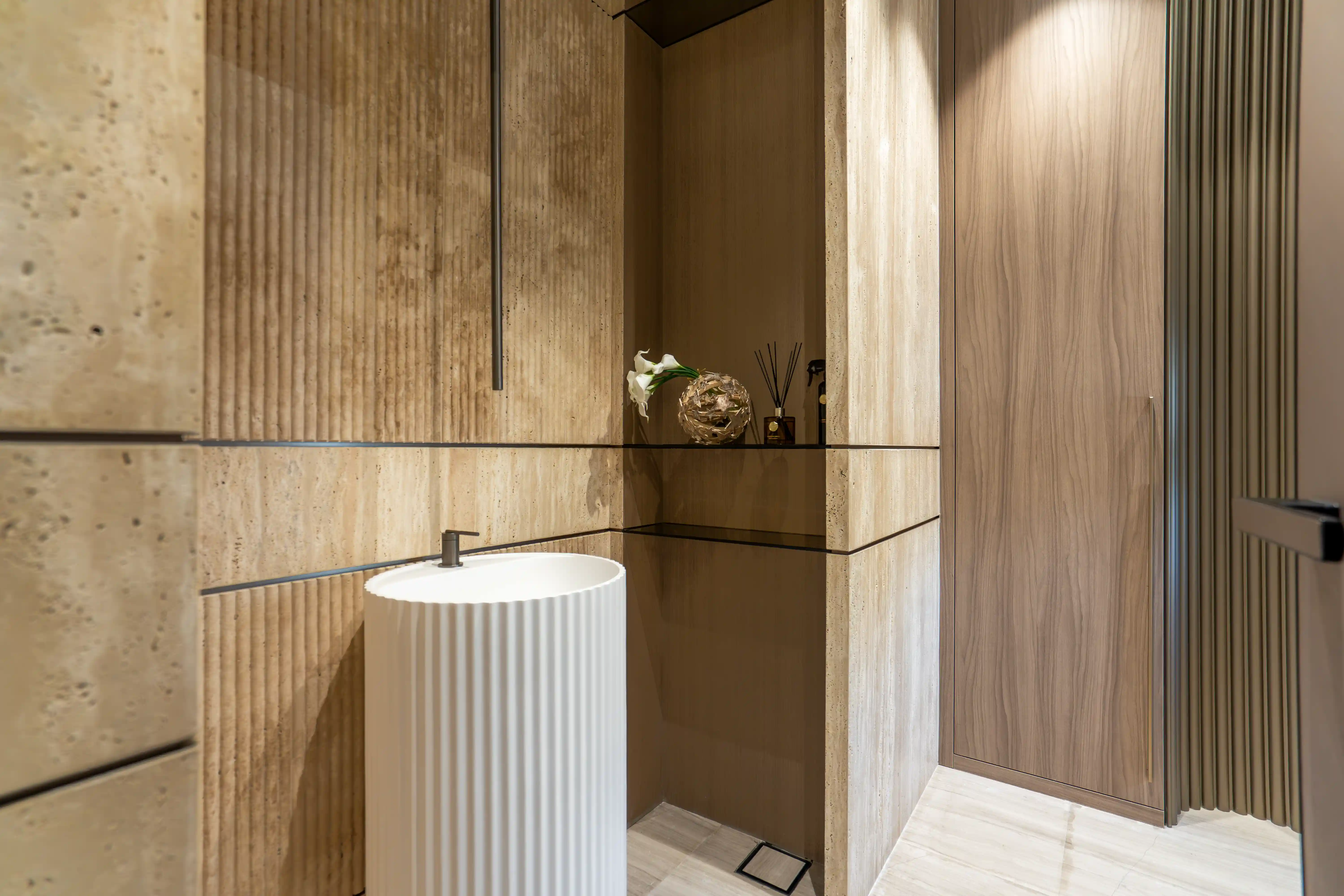 Powder room with fluted marbles, flexible travertine and washbasin.