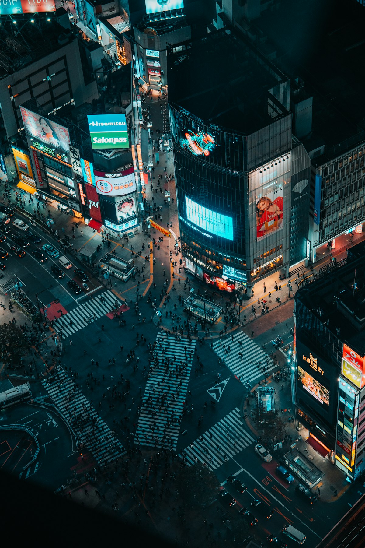 Shibuya Crossing at dusk with neon lights and crowds, a busy japan travel itinerary stop