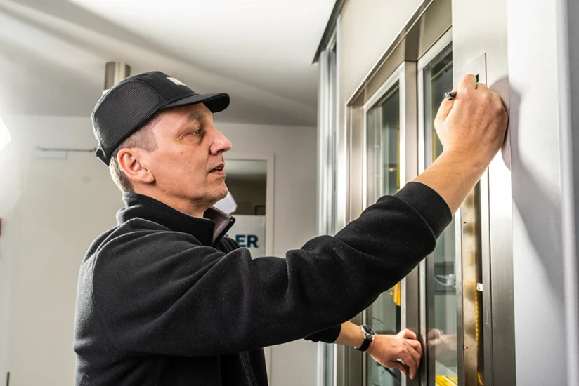 Servicetechniker bei Wartungsarbeit an Aufzugsanlage – professionelles Business Portrait.