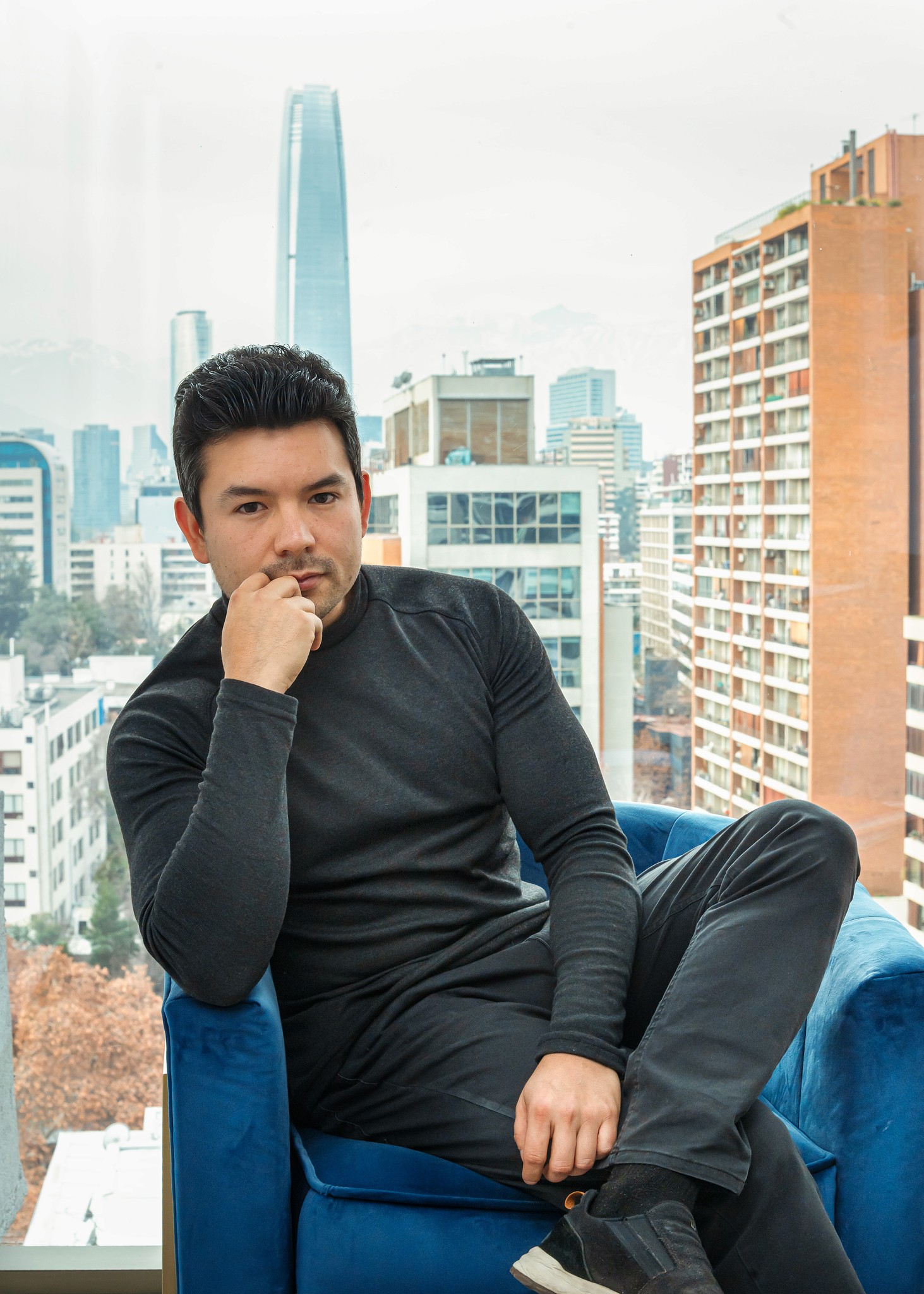 Hombre en posición de reposo con la ciudad de fondo