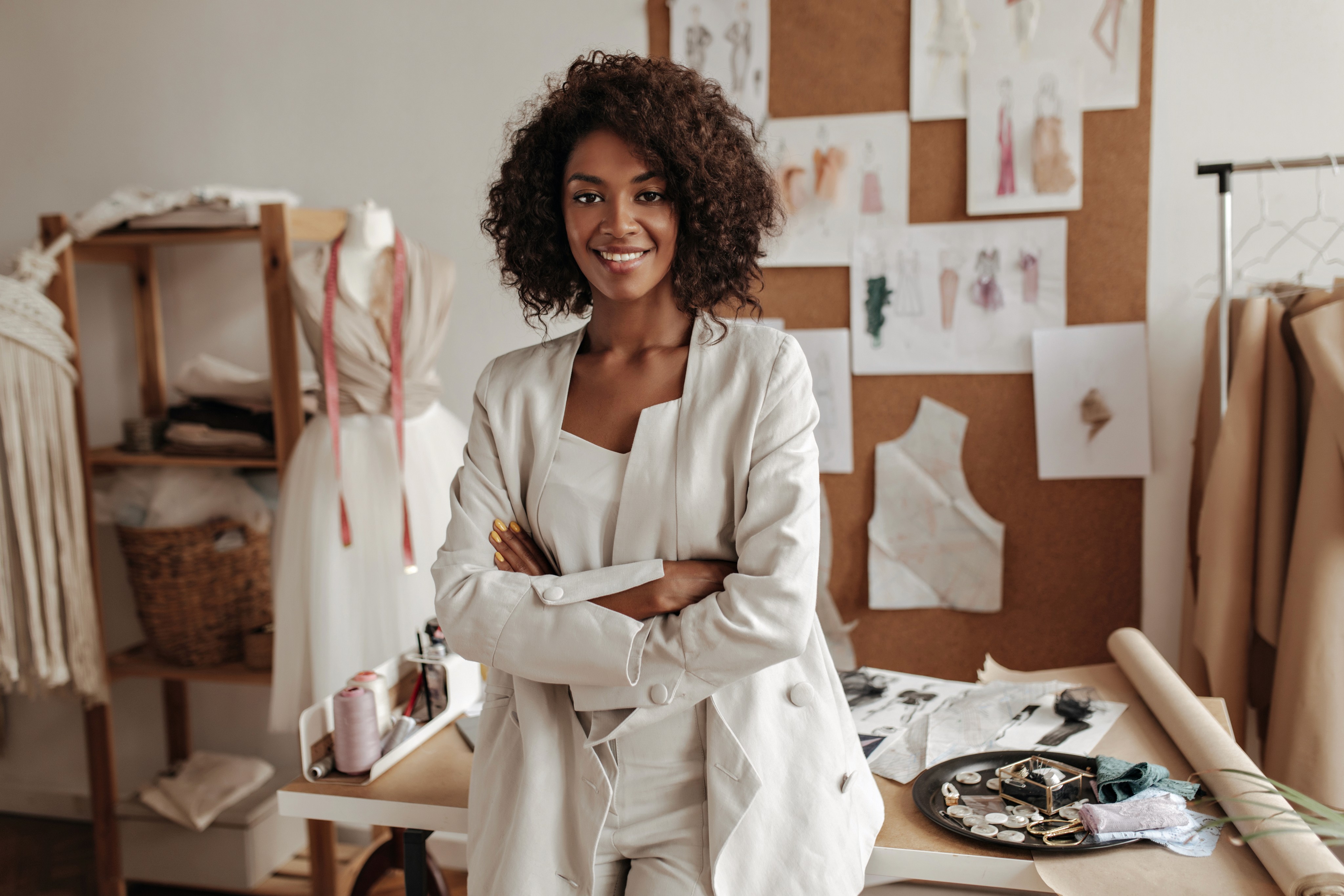 A female fashion designer standing up and folding her arms