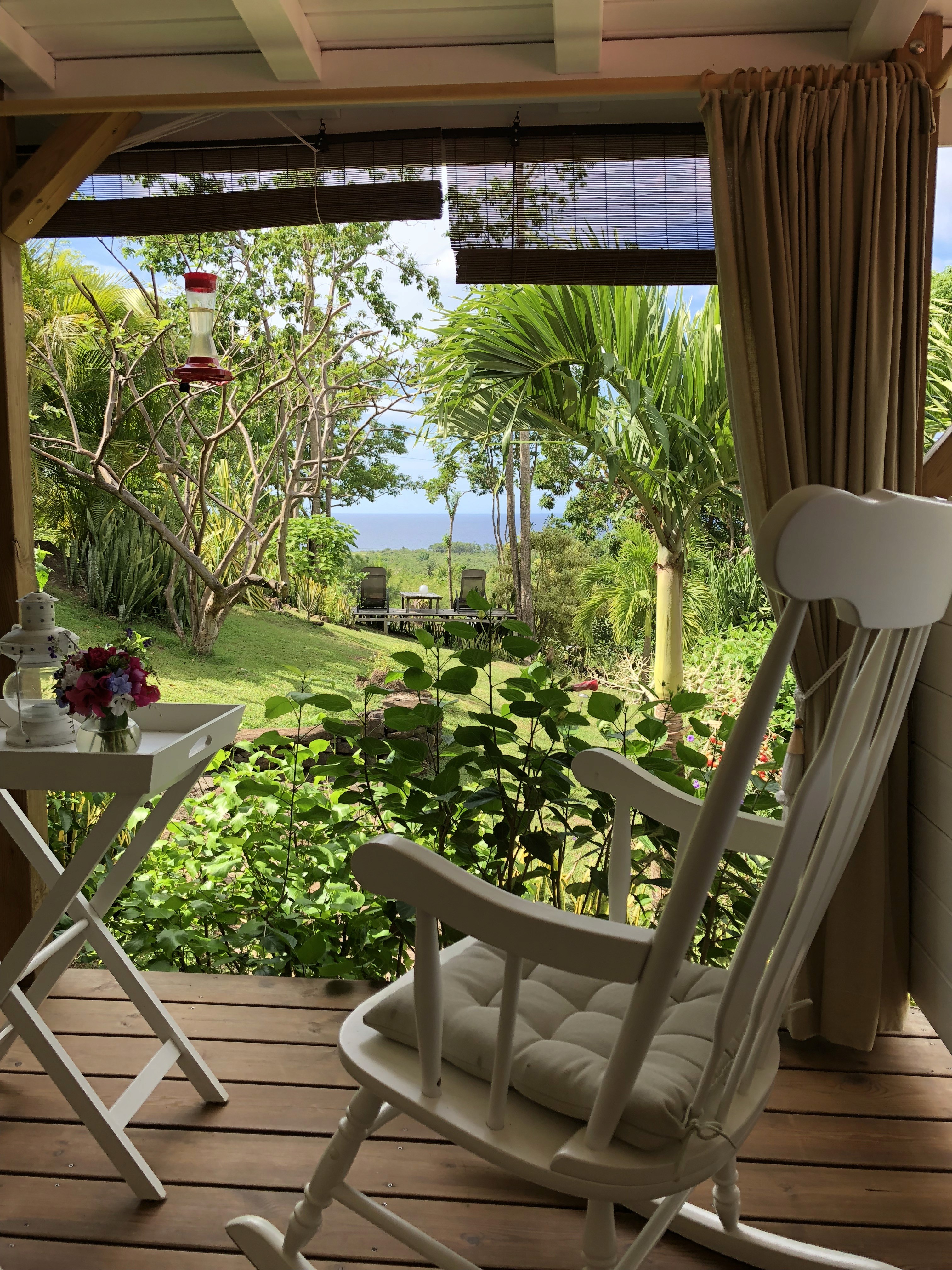 fauteuil à bascule avec vue sur le jardin tropical et la mer des caraïbes en Guadeloupe