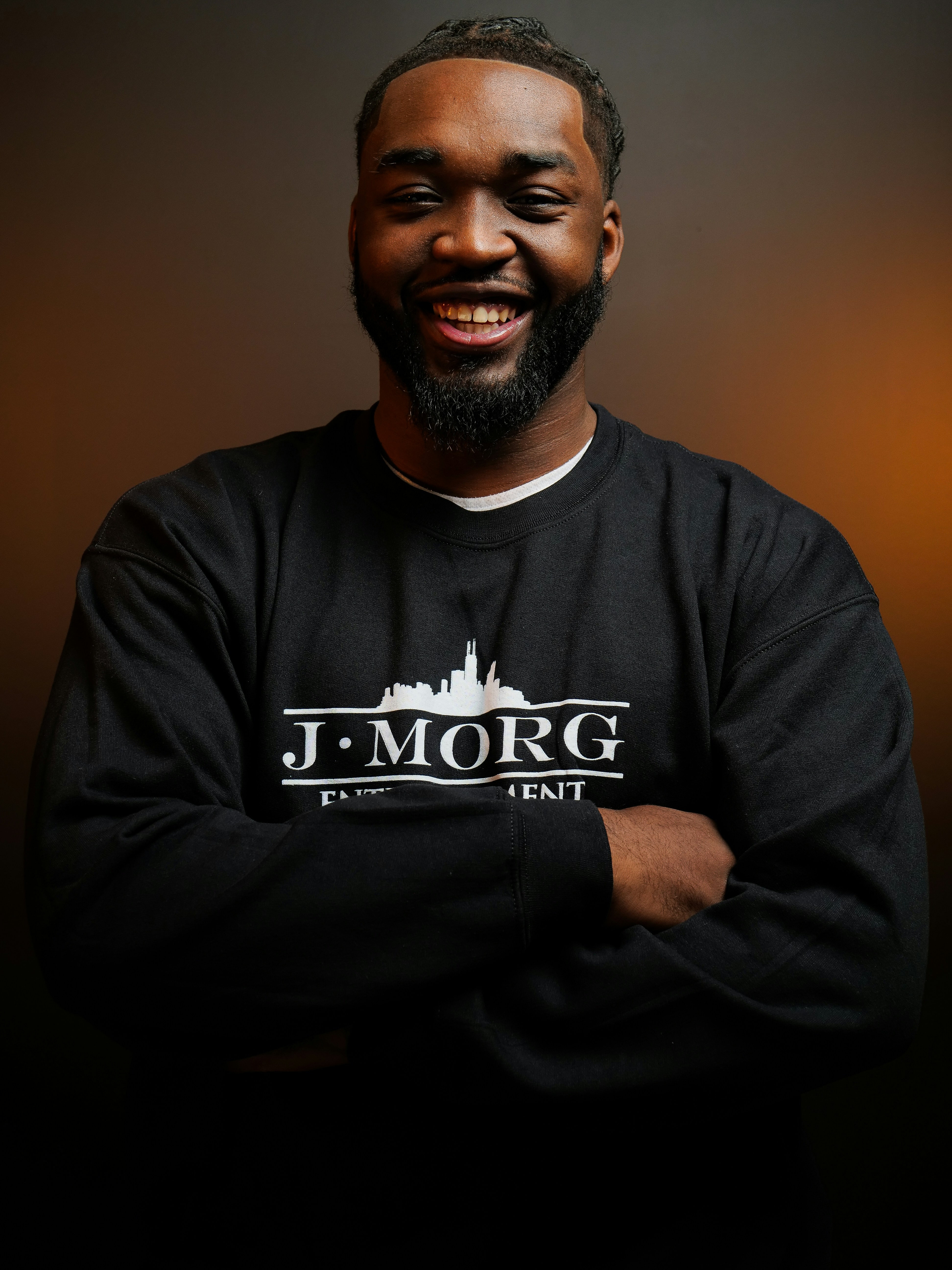 A smiling black man wearing a black sweatshirt.