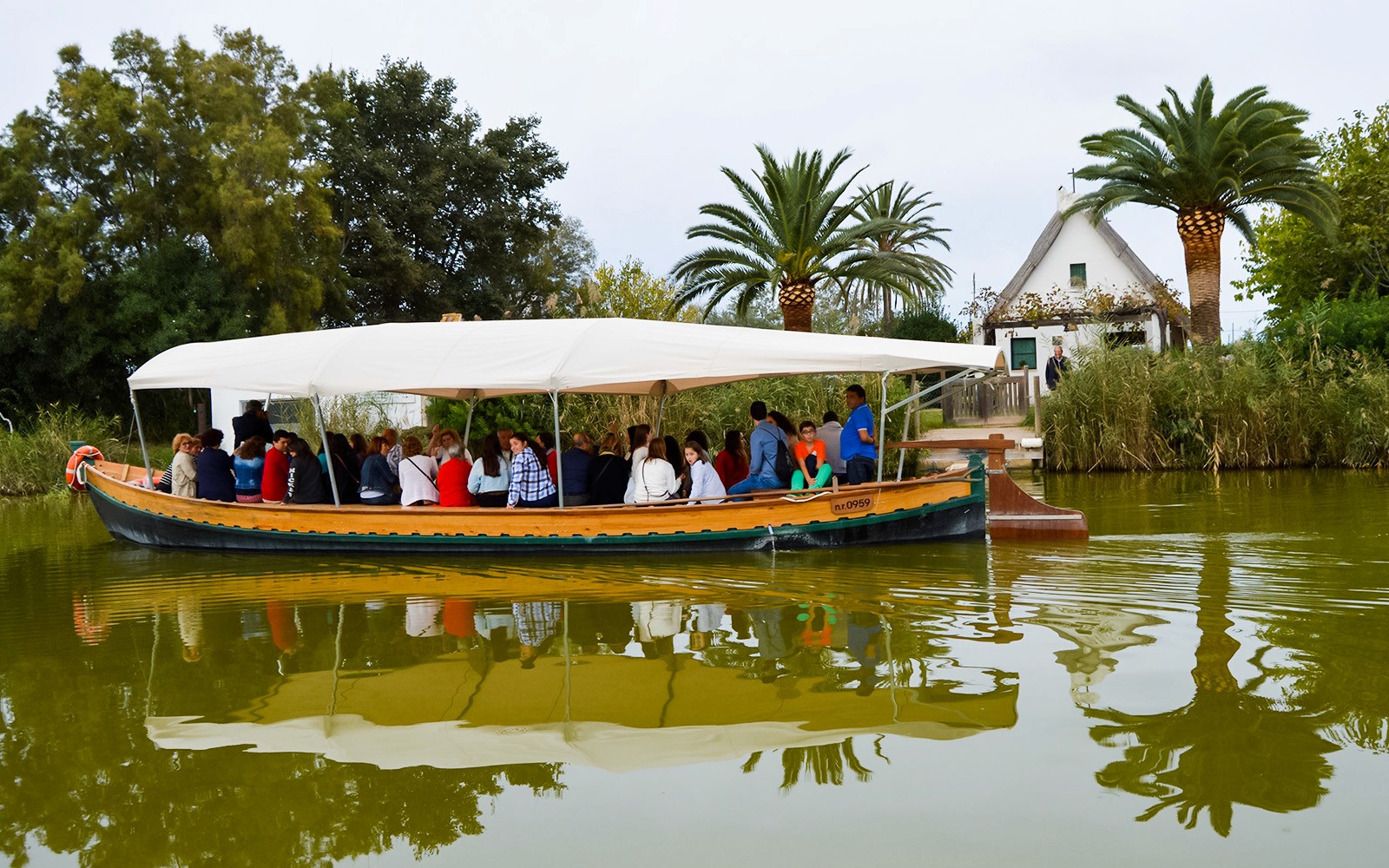 Boat ride with tourists at Albufeira Natural Park, surrounded by lush greenery.