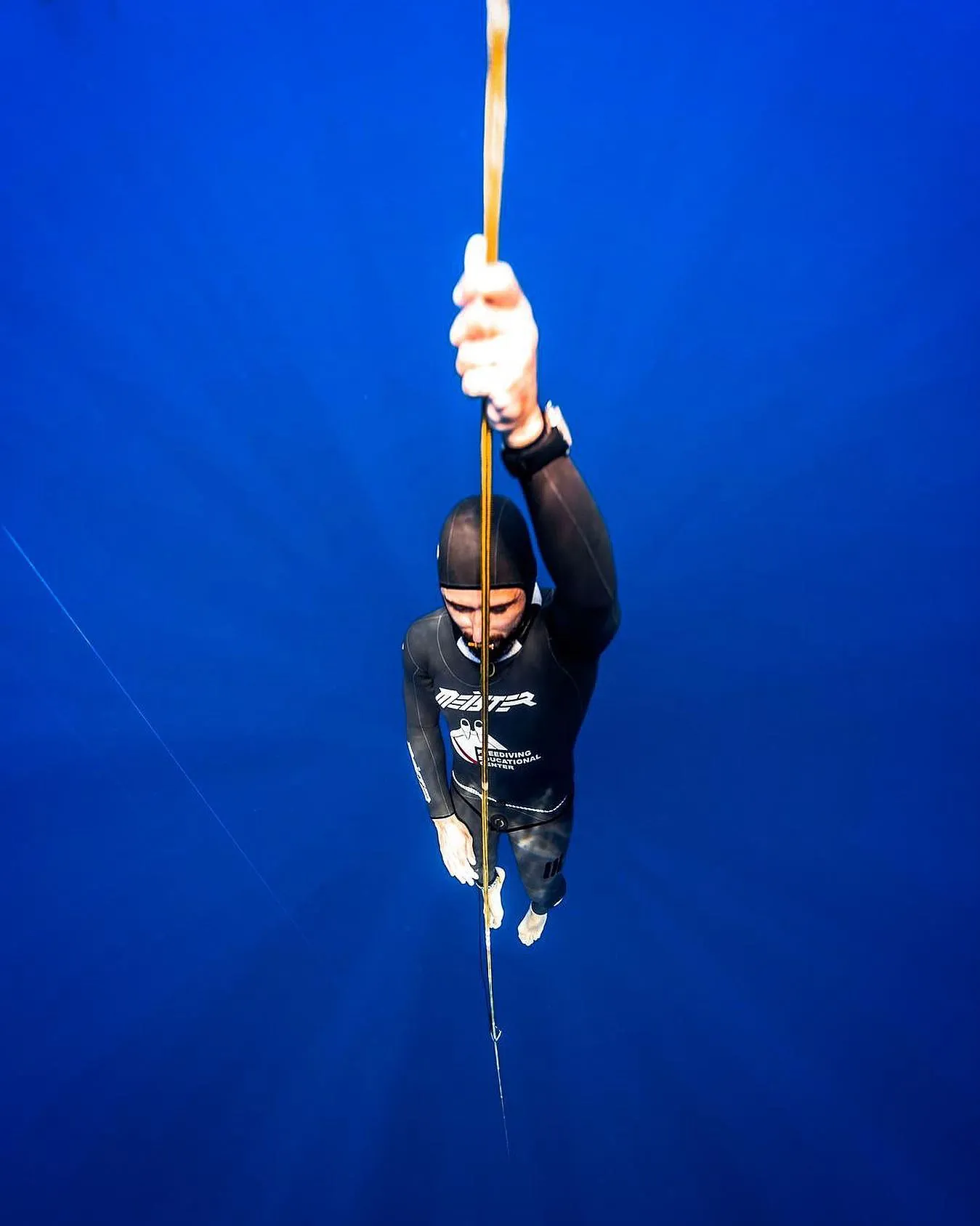 freediver meister lying on water with another freediverhelping