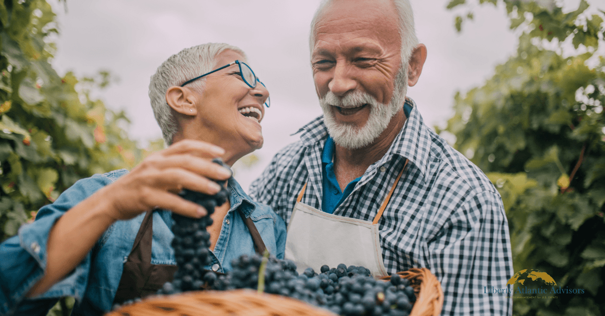 Two Americans who retired in France smile and pick blueberries.