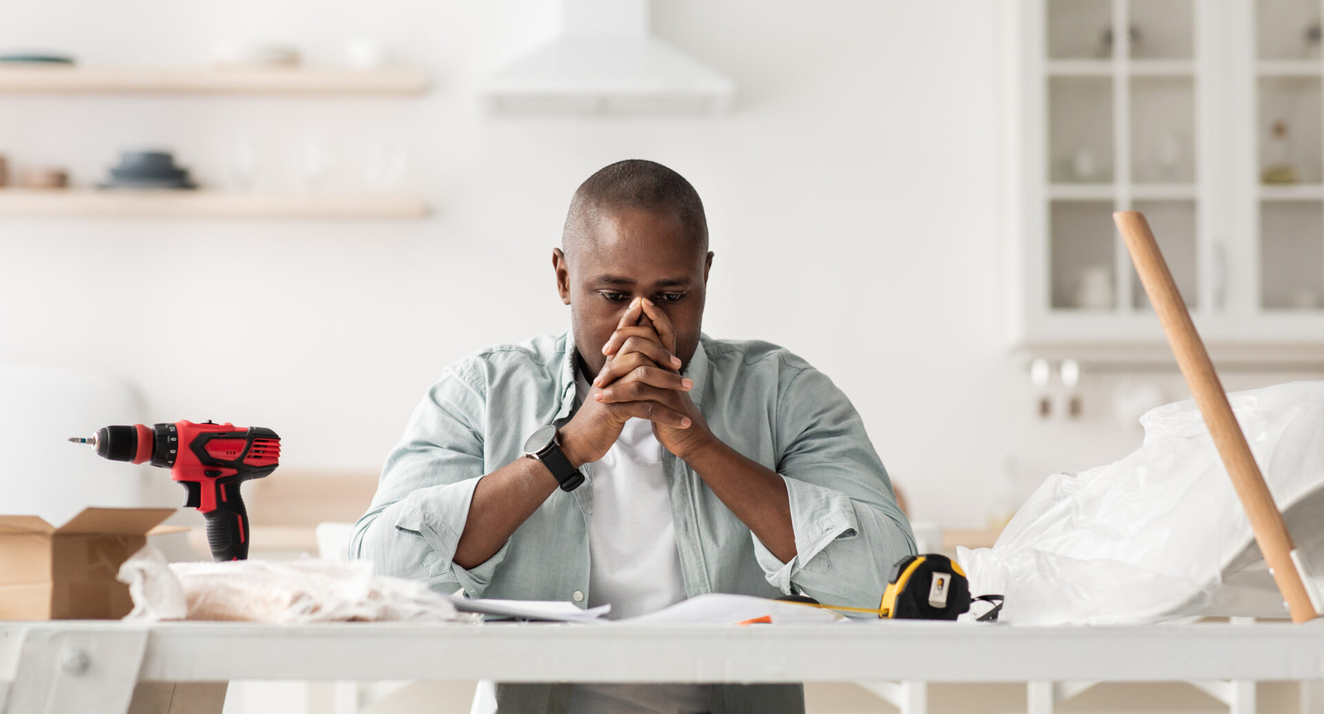 Upset man with tools and equipment troubleshooting motorized blinds. Wholesale Blind Factory